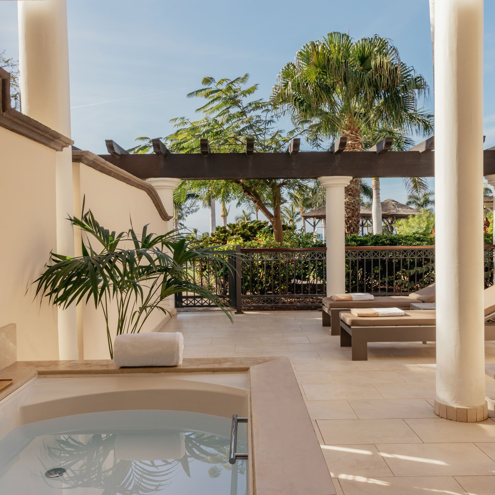 a hot tub and lounge chairs on a patio