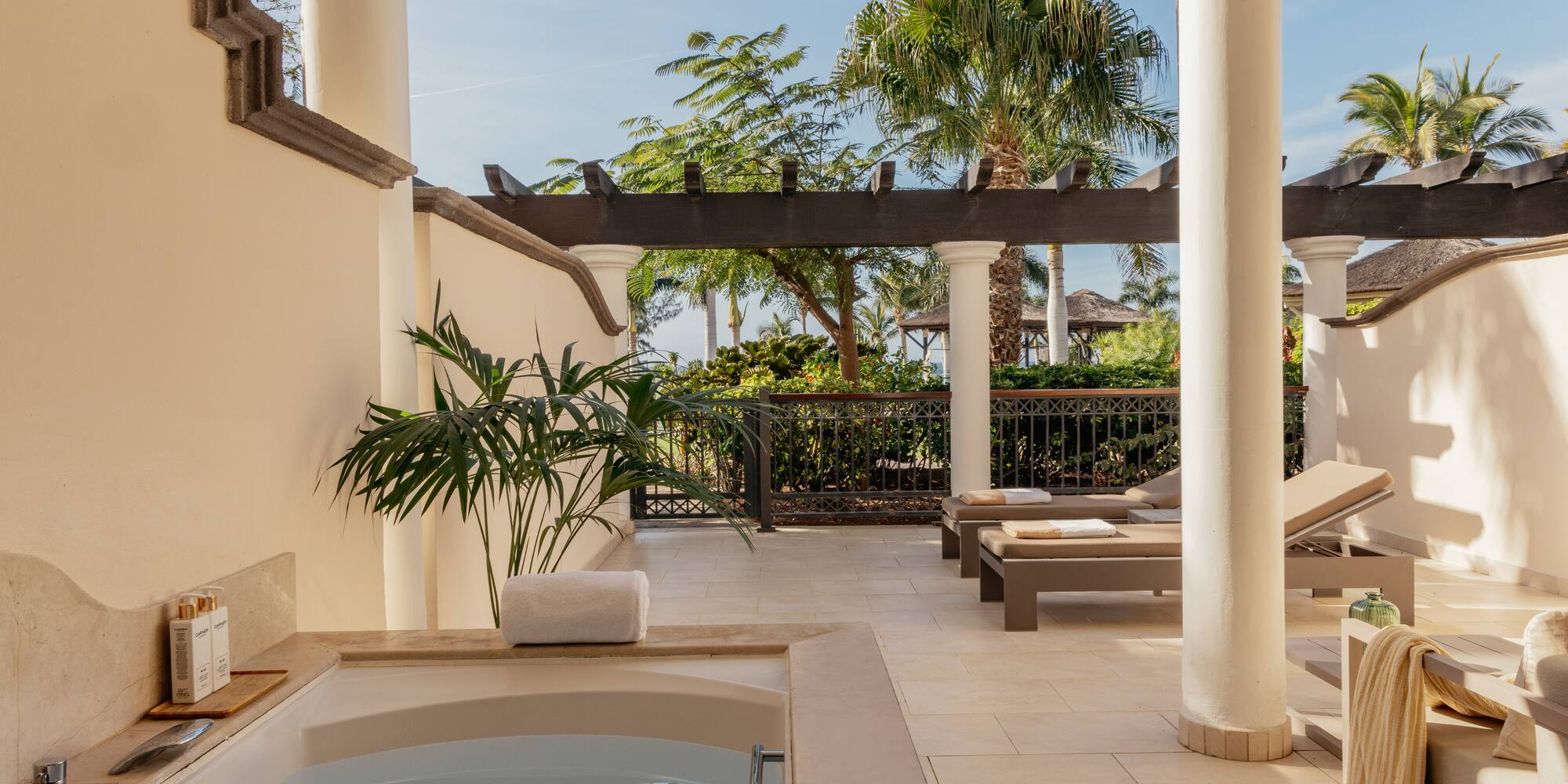 a hot tub and lounge chairs on a patio
