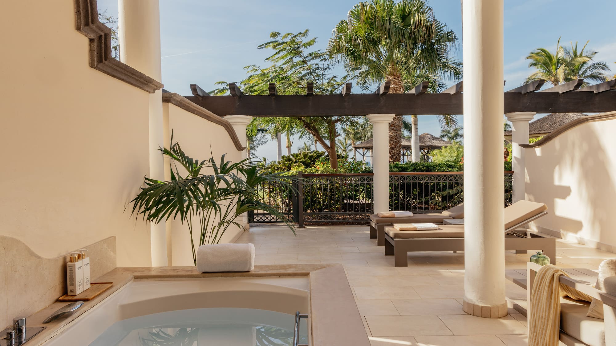 a hot tub and lounge chairs on a patio