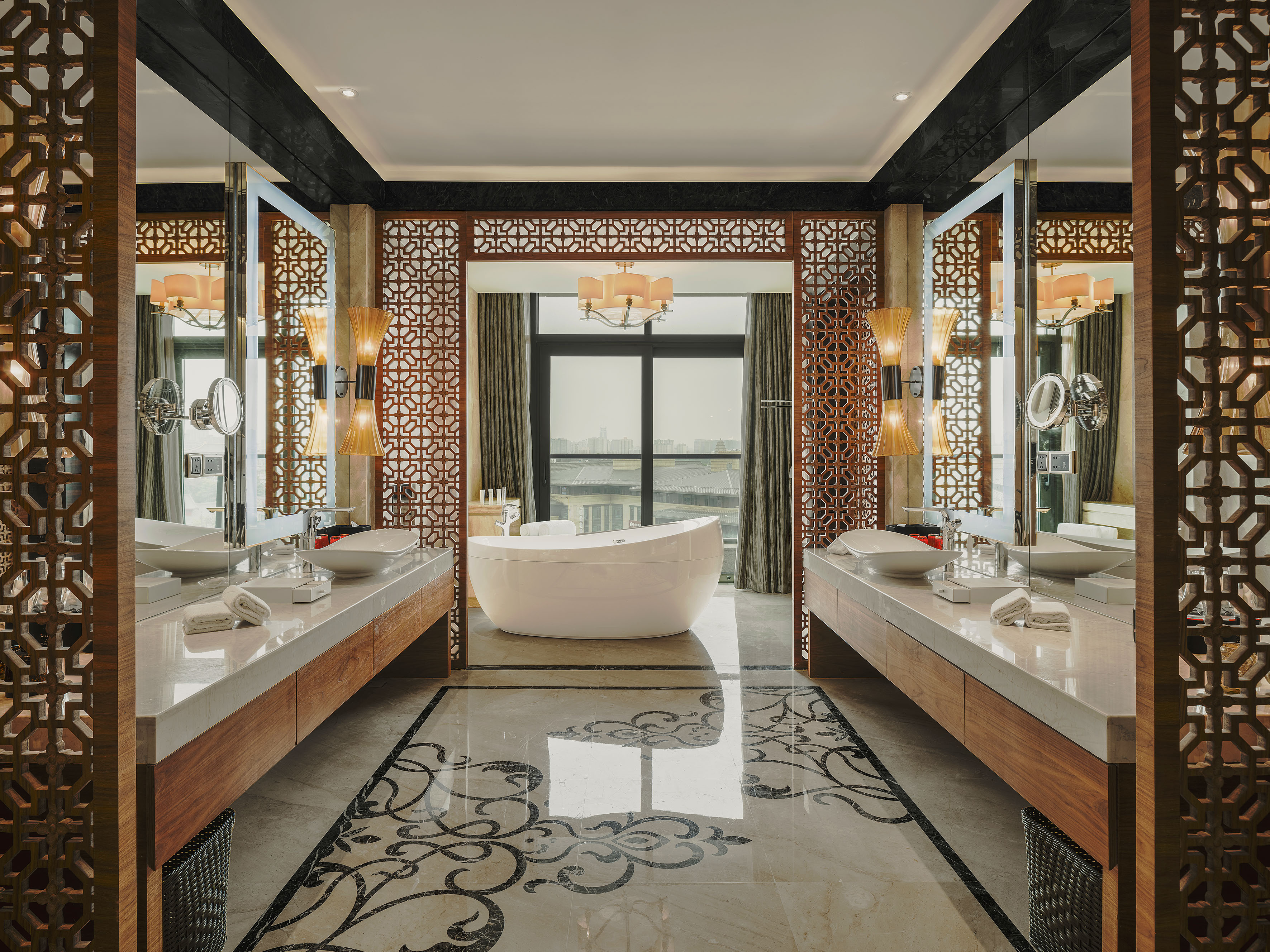 Elegant luxury bathroom with freestanding tub, dual vanity, ornate wood screens.