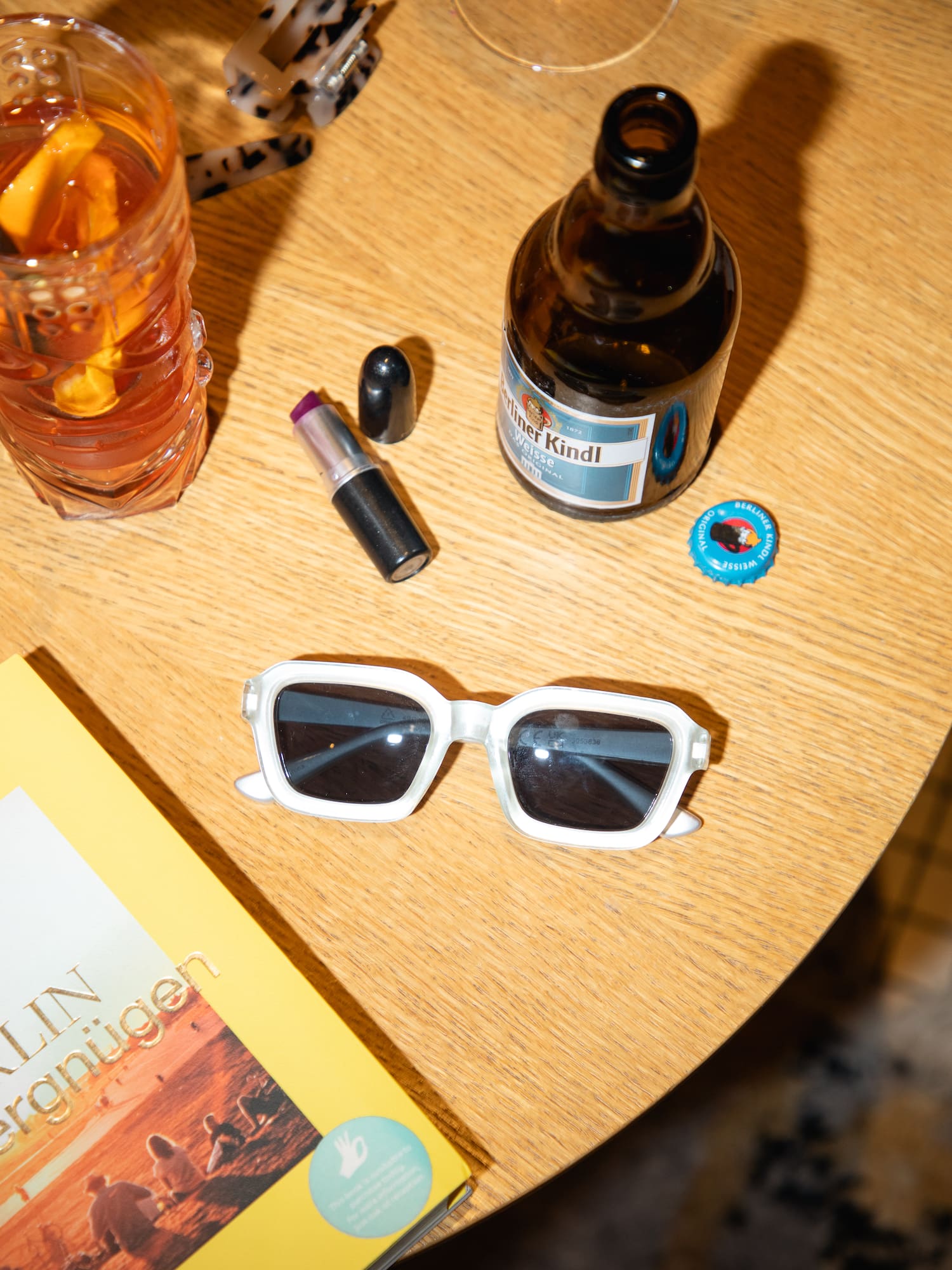 a table with a book and glasses and a drink