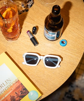 a table with a book and glasses and a drink
