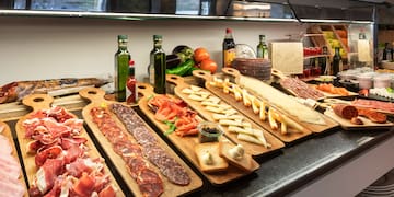a counter with different types of meat on wooden boards