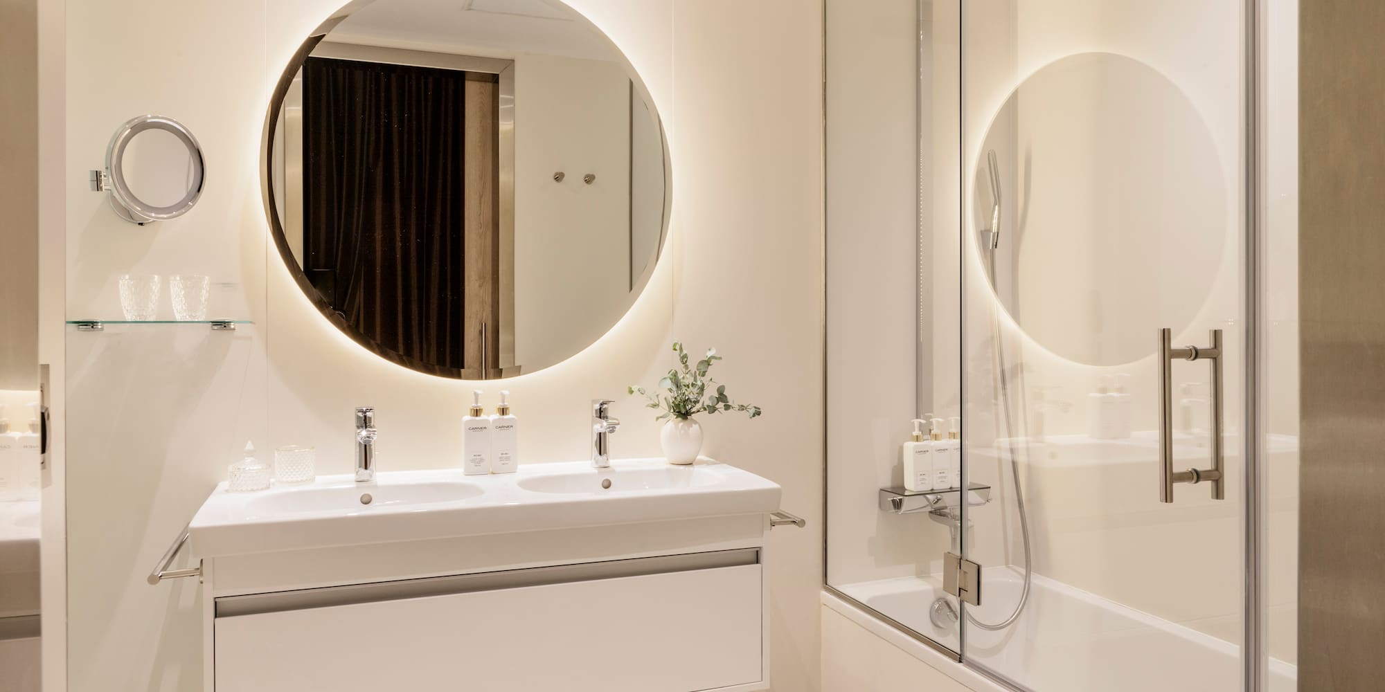 a bathroom with a round mirror and a tub