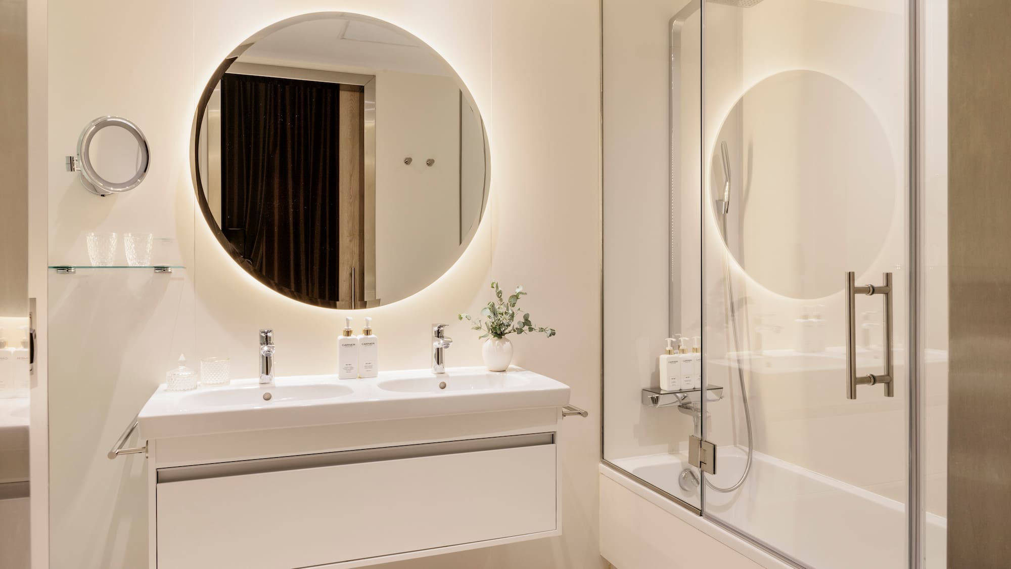 a bathroom with a round mirror and a tub