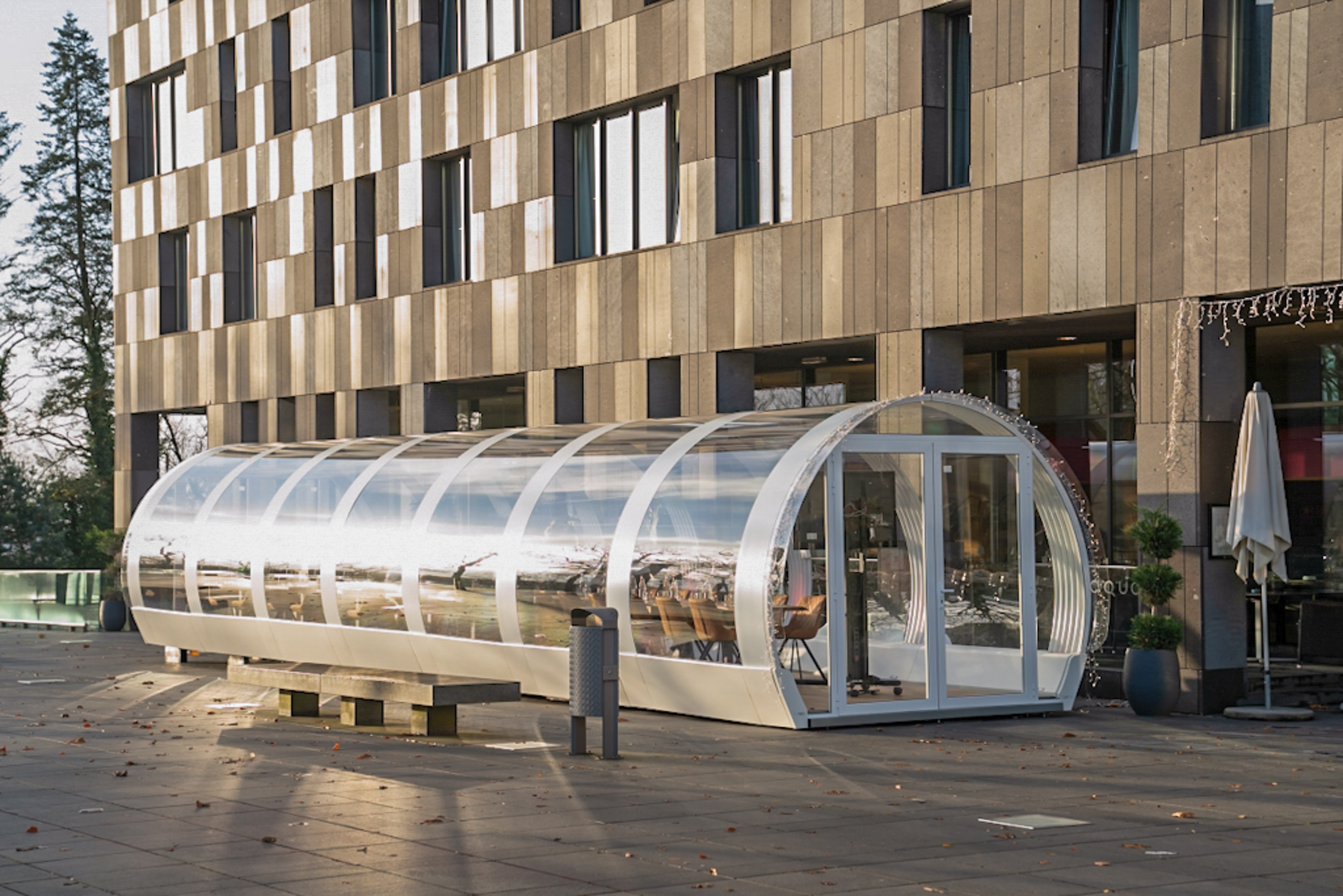 a glass covered shelter in front of a building