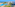 Coastal resort with big pools, water slides, palm trees, and ocean.