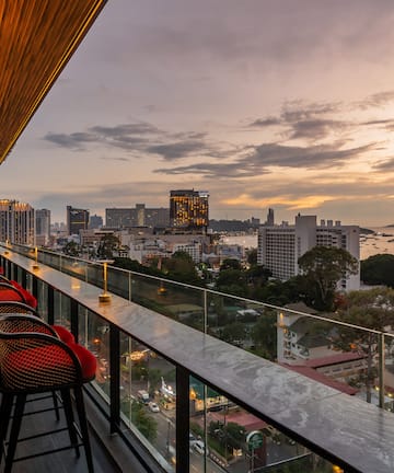 a balcony with chairs and a view of a city