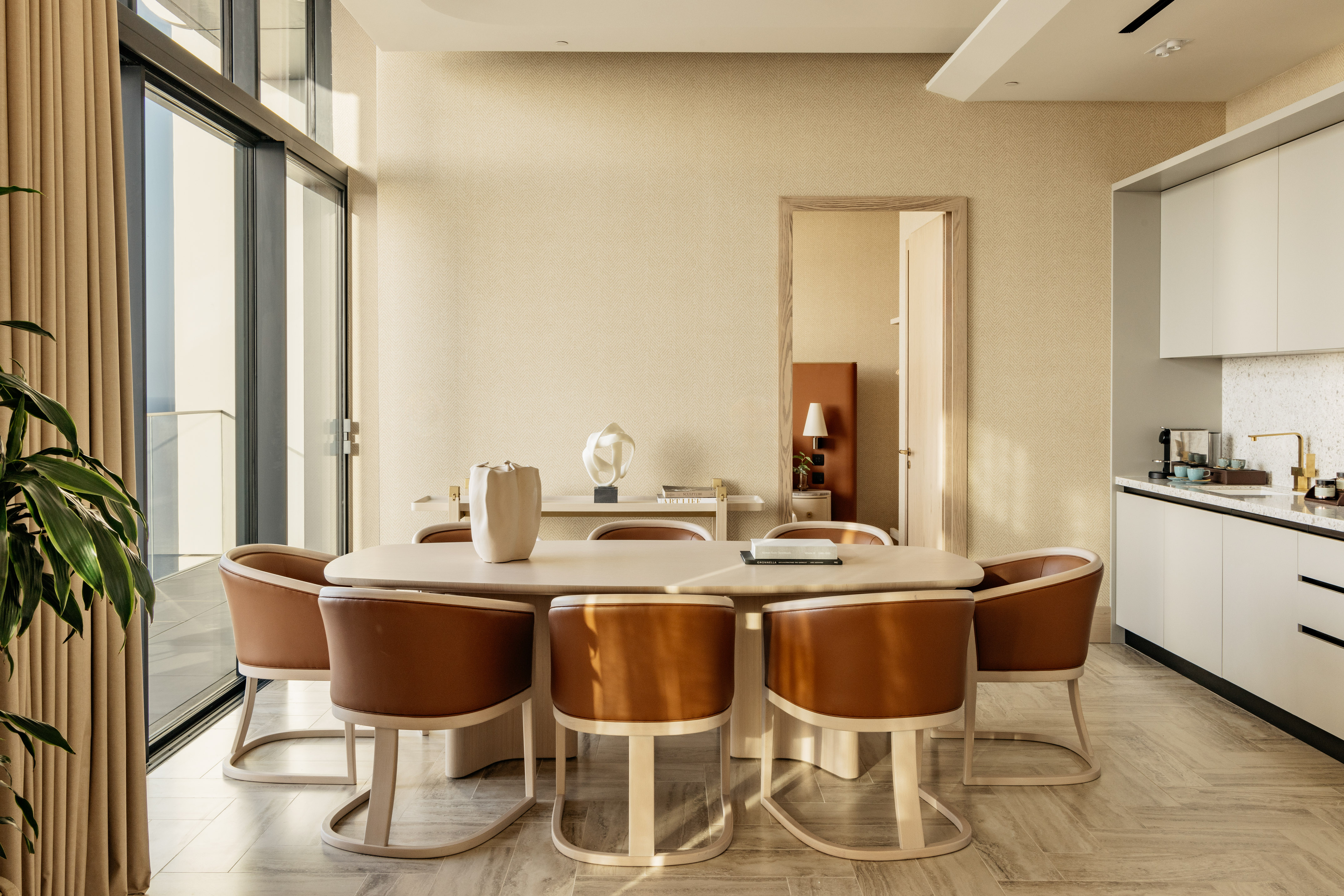 Open concept dining room with wood table and brown leather chairs.