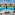 Resort hotel balcony view: large swimming pool, palm trees, sun loungers.