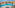 Balcony view of hotel resort pool with sun loungers and palm trees.