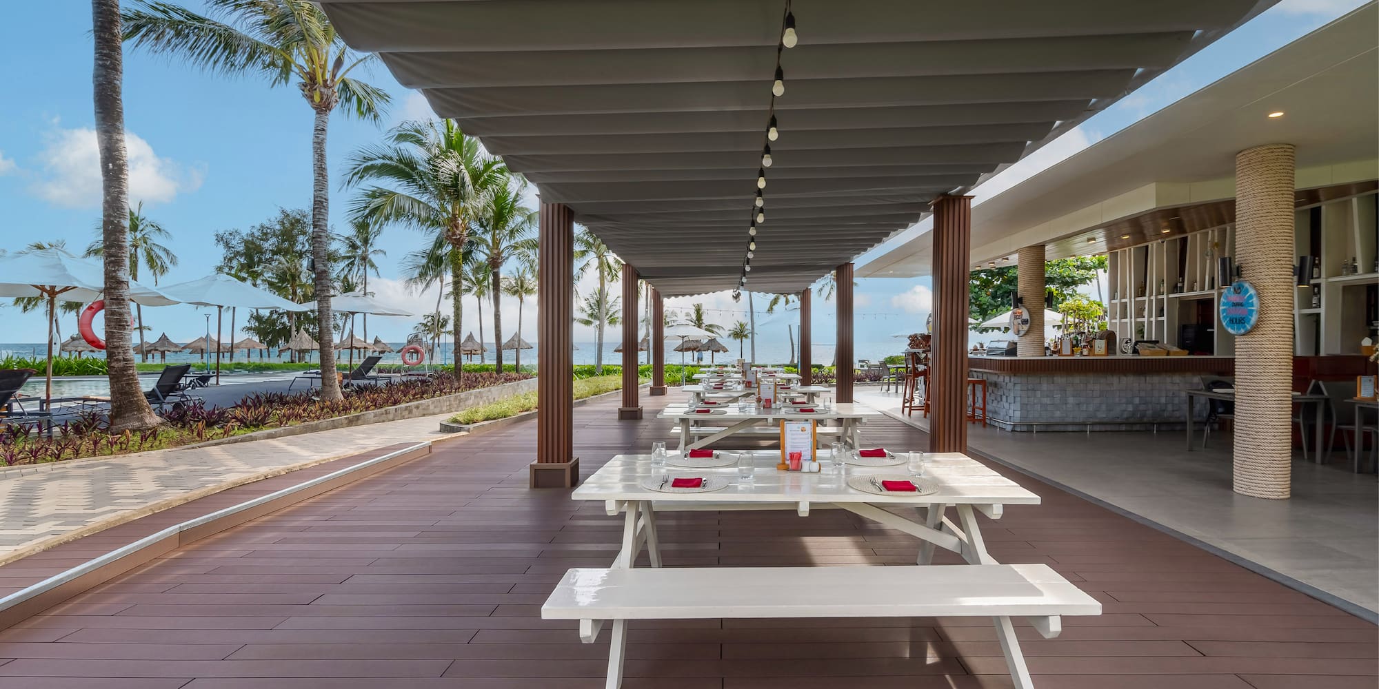 a covered patio with tables and chairs
