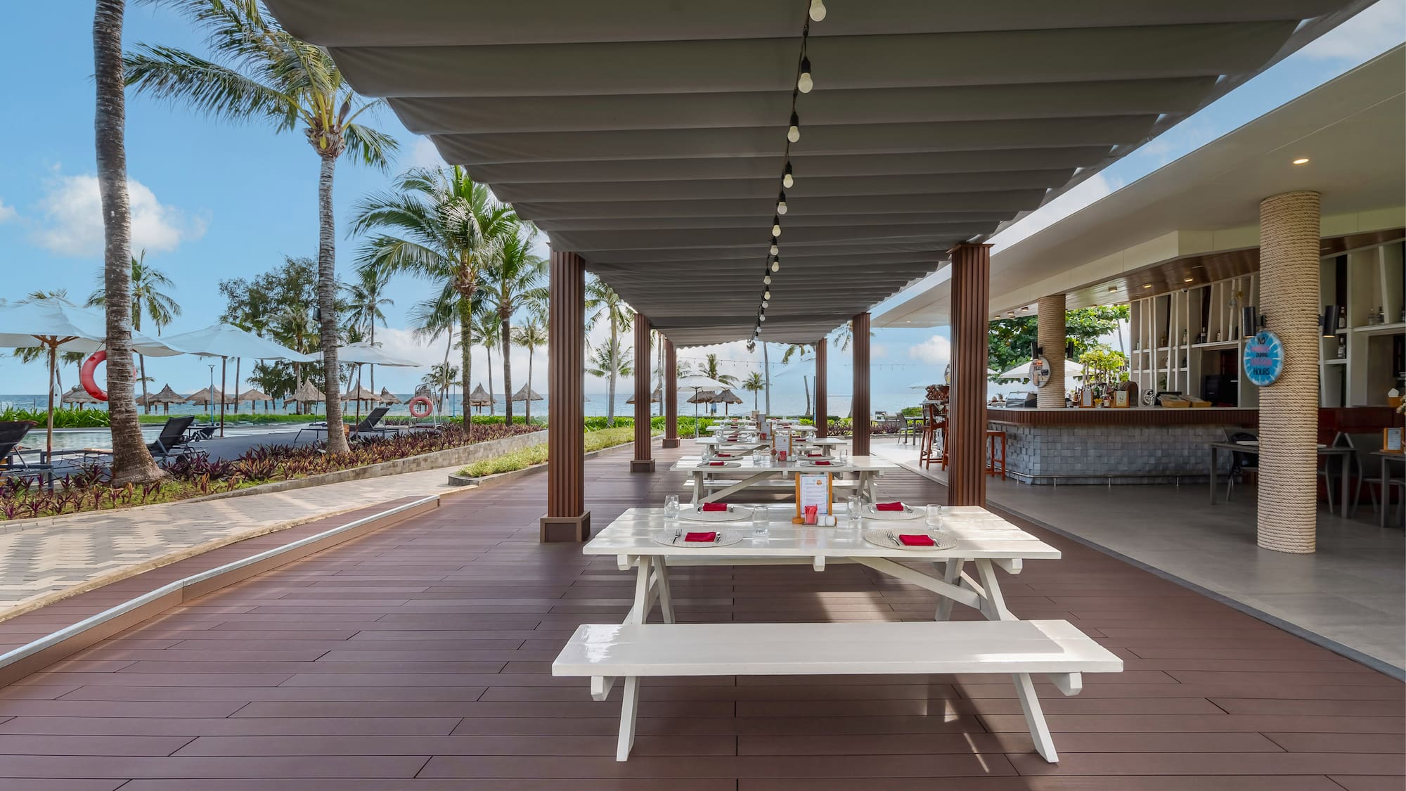 a covered patio with tables and chairs