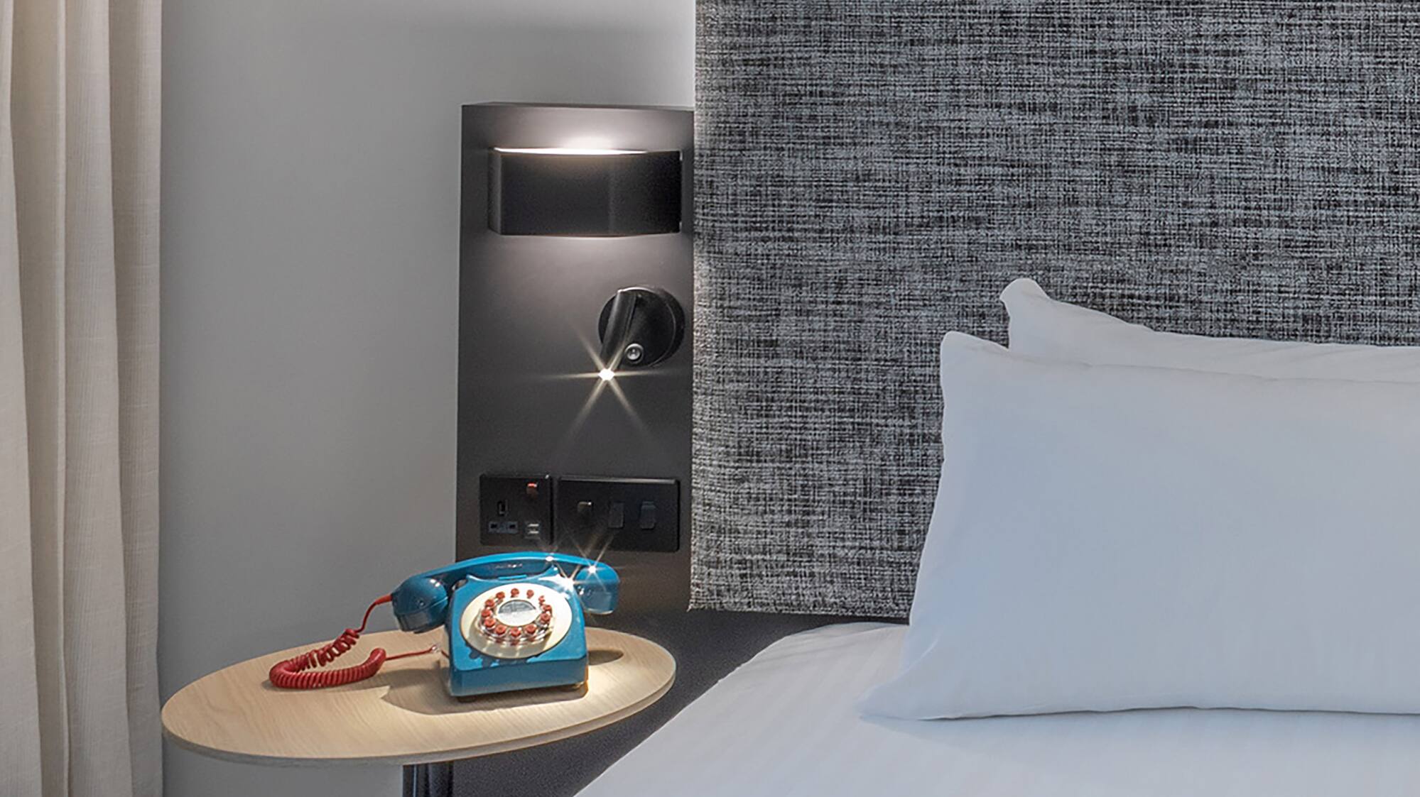 a bed with a telephone on a table