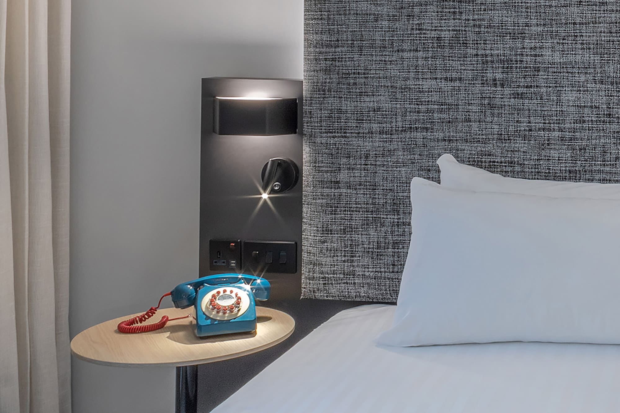 a bed with a telephone on a table