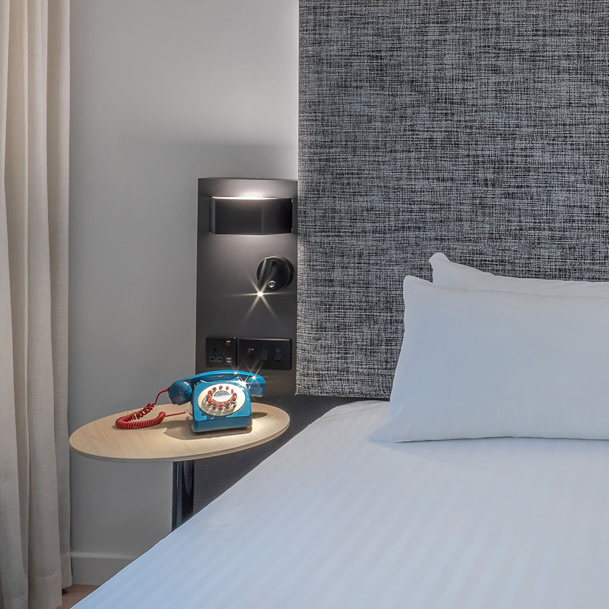 a bed with a telephone on a table