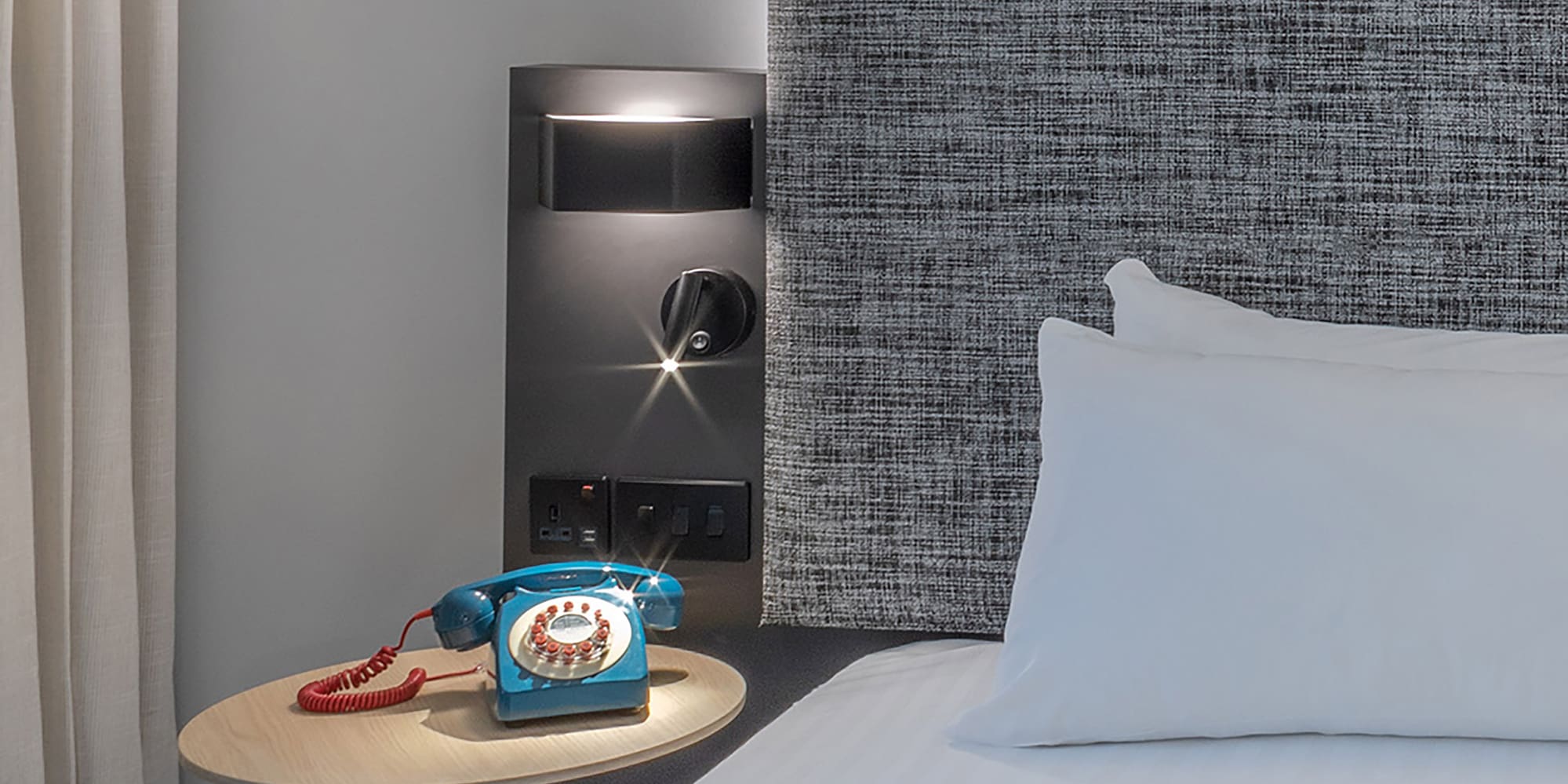 a bed with a telephone on a table