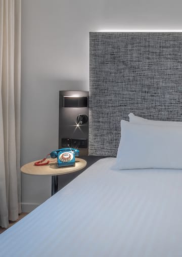 a bed with a telephone on a table