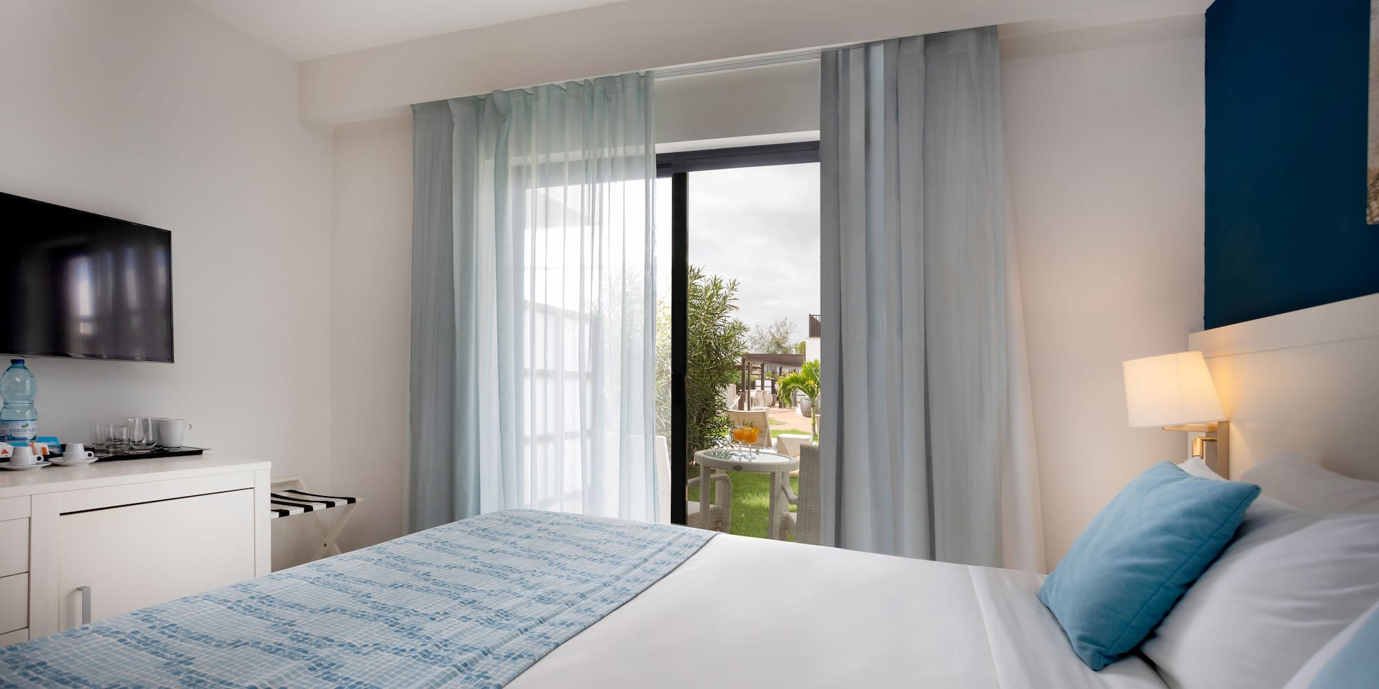 a bed with a lamp and a table with a piano keyboard