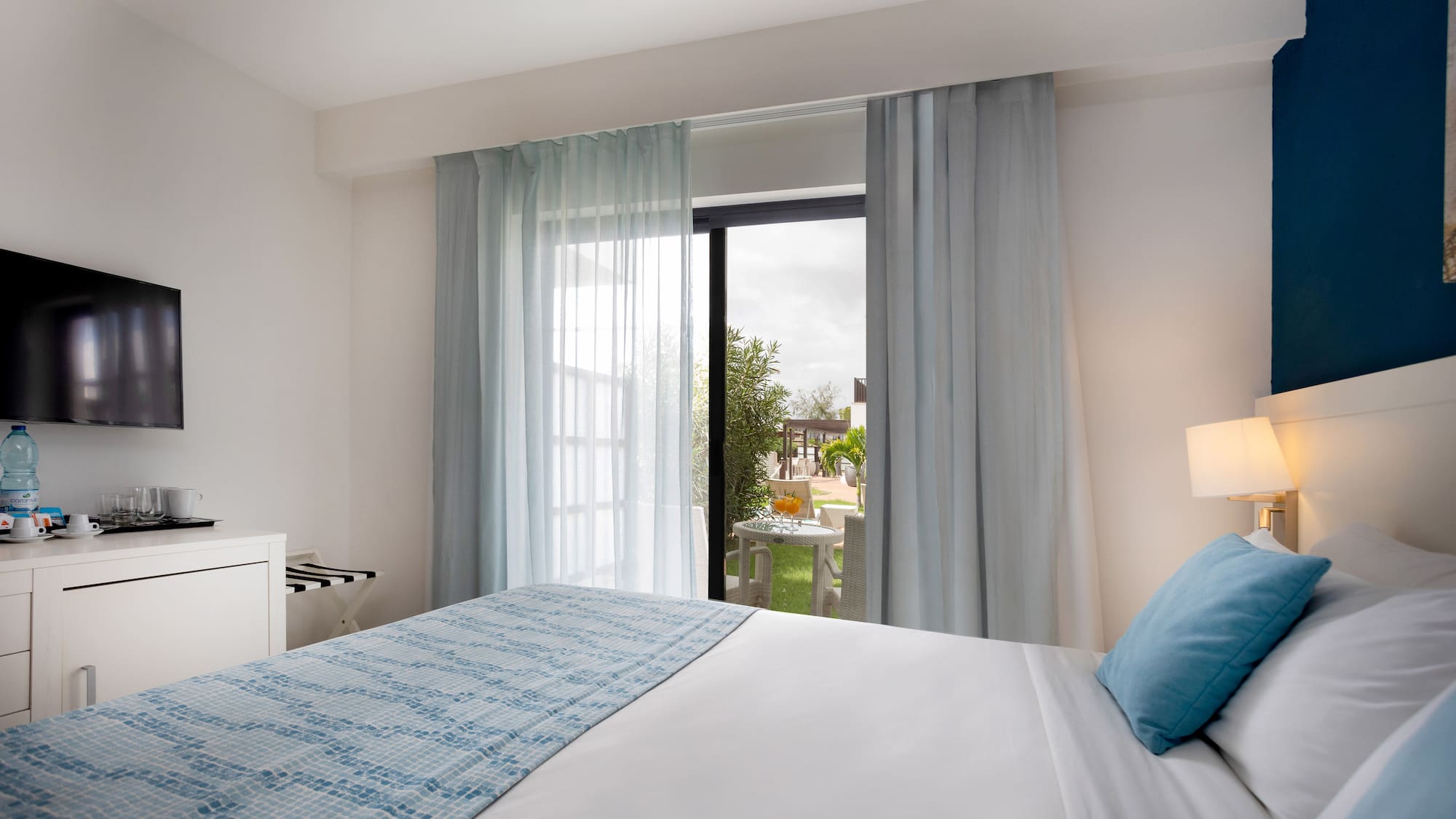 a bed with a lamp and a table with a piano keyboard