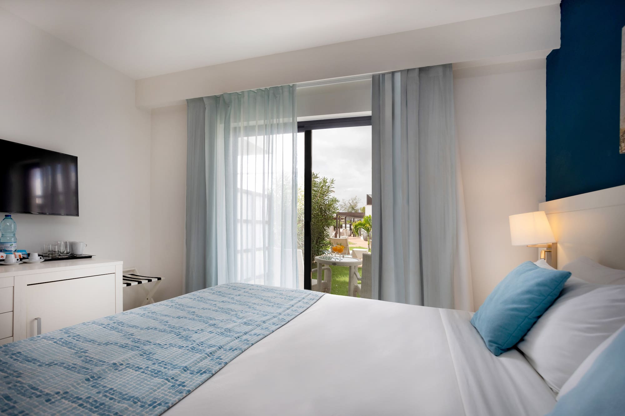 a bed with a lamp and a table with a piano keyboard