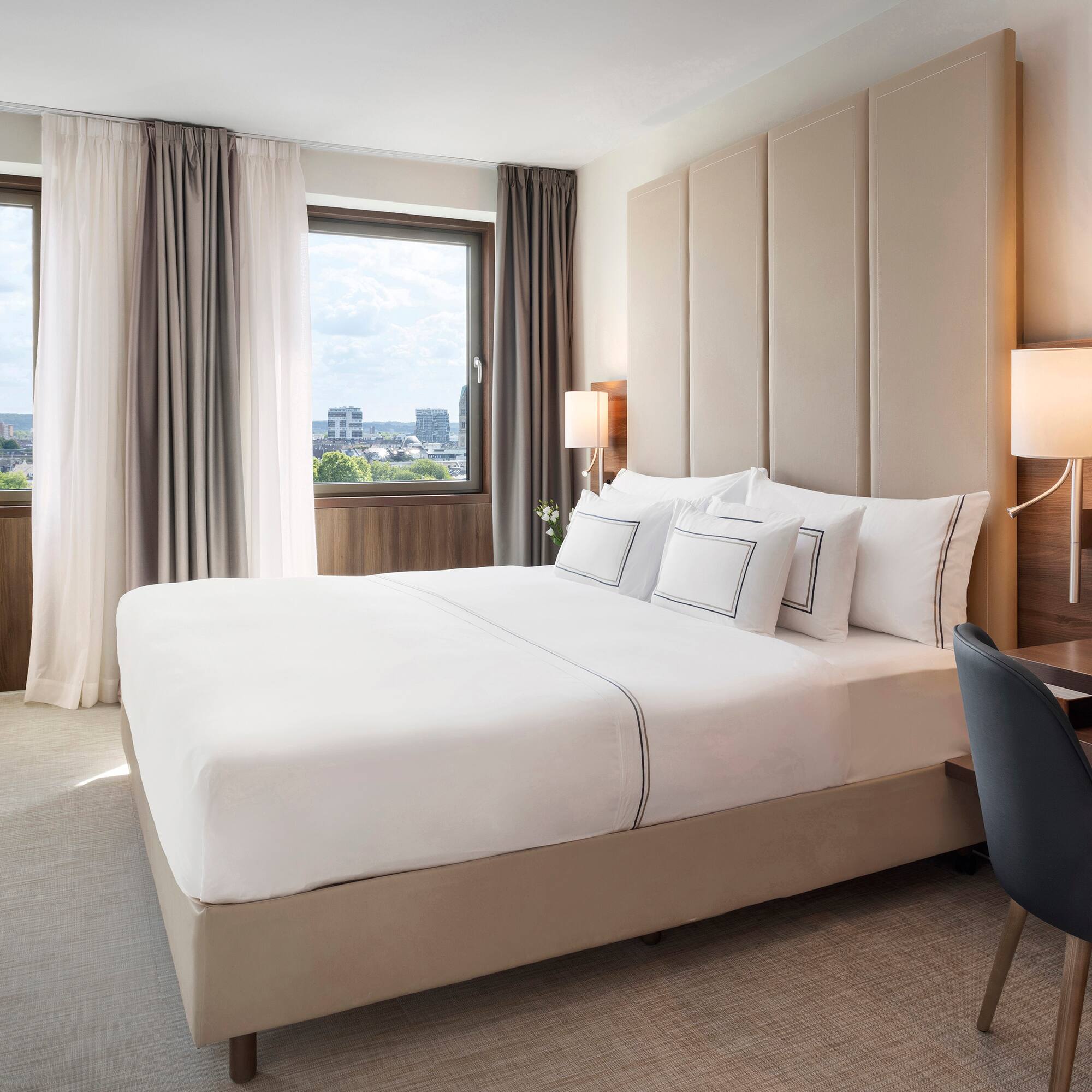 a bed with a chair and a desk in a hotel room