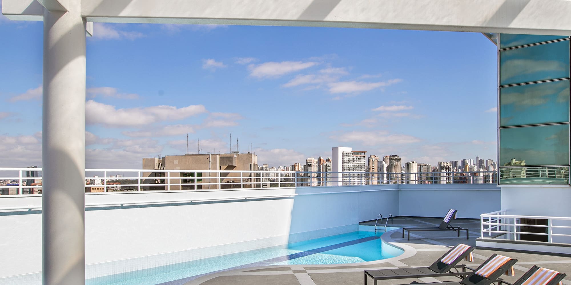 a pool with lounge chairs on a rooftop