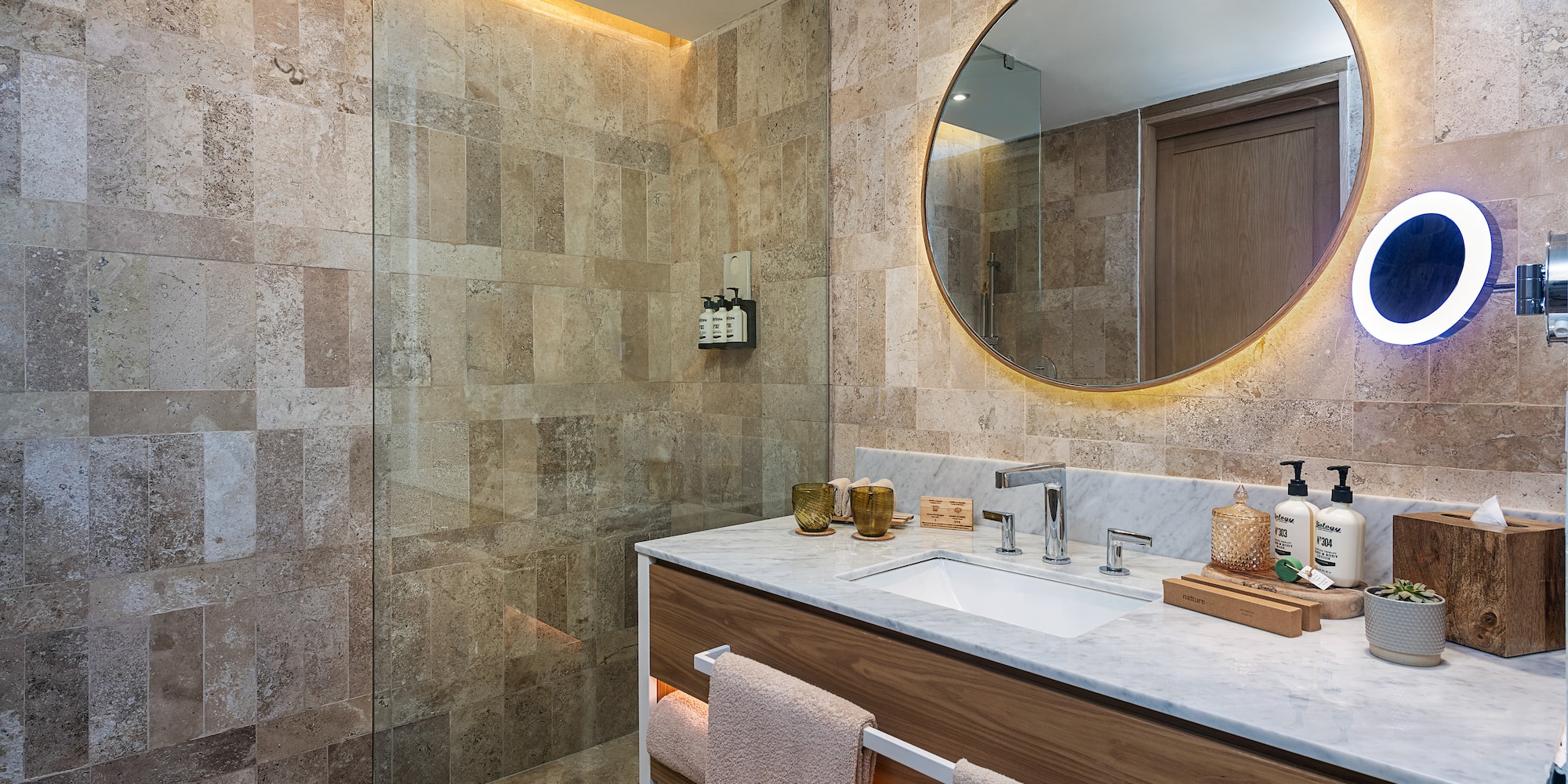 a bathroom with a round mirror and a shower