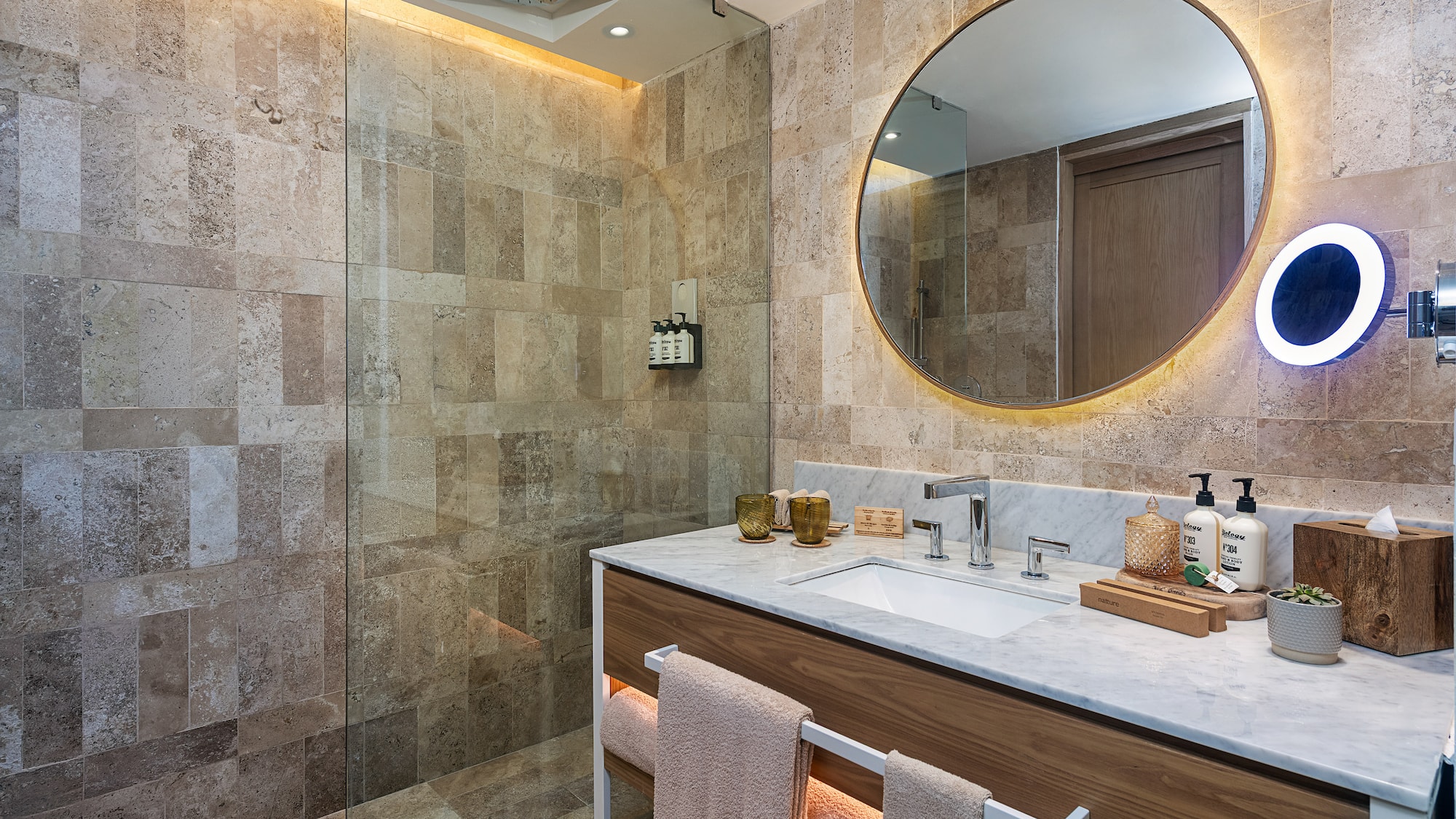 a bathroom with a round mirror and a shower