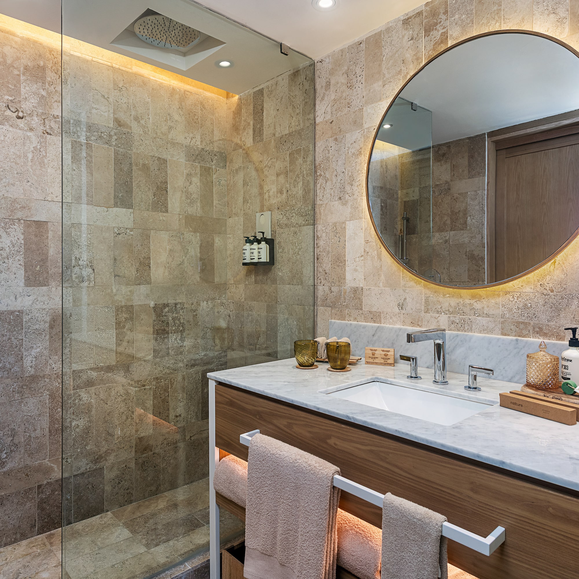 a bathroom with a round mirror and a shower