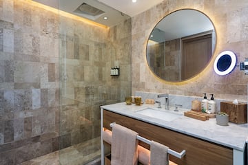 a bathroom with a round mirror and a shower