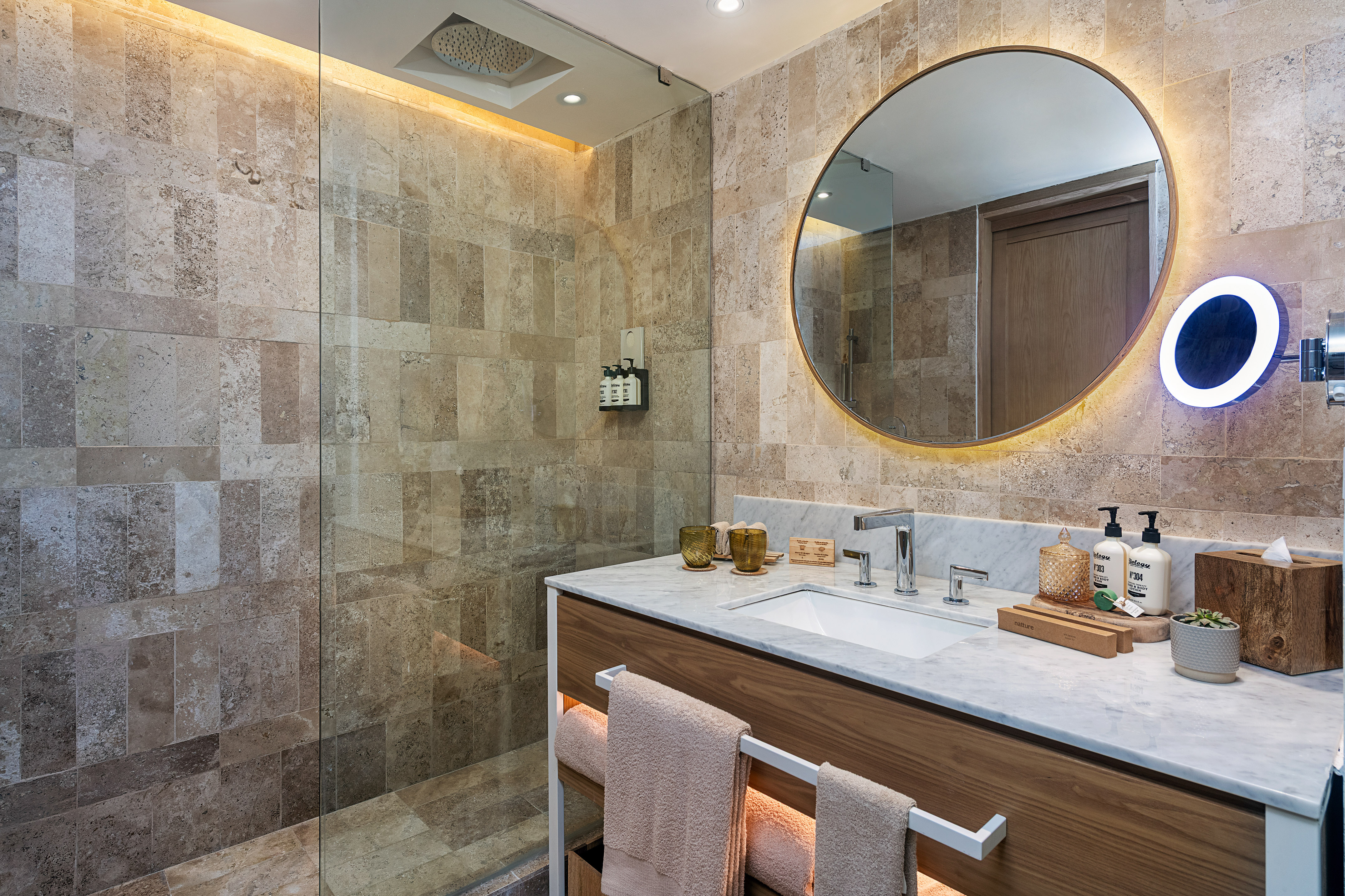 a bathroom with a round mirror and a shower