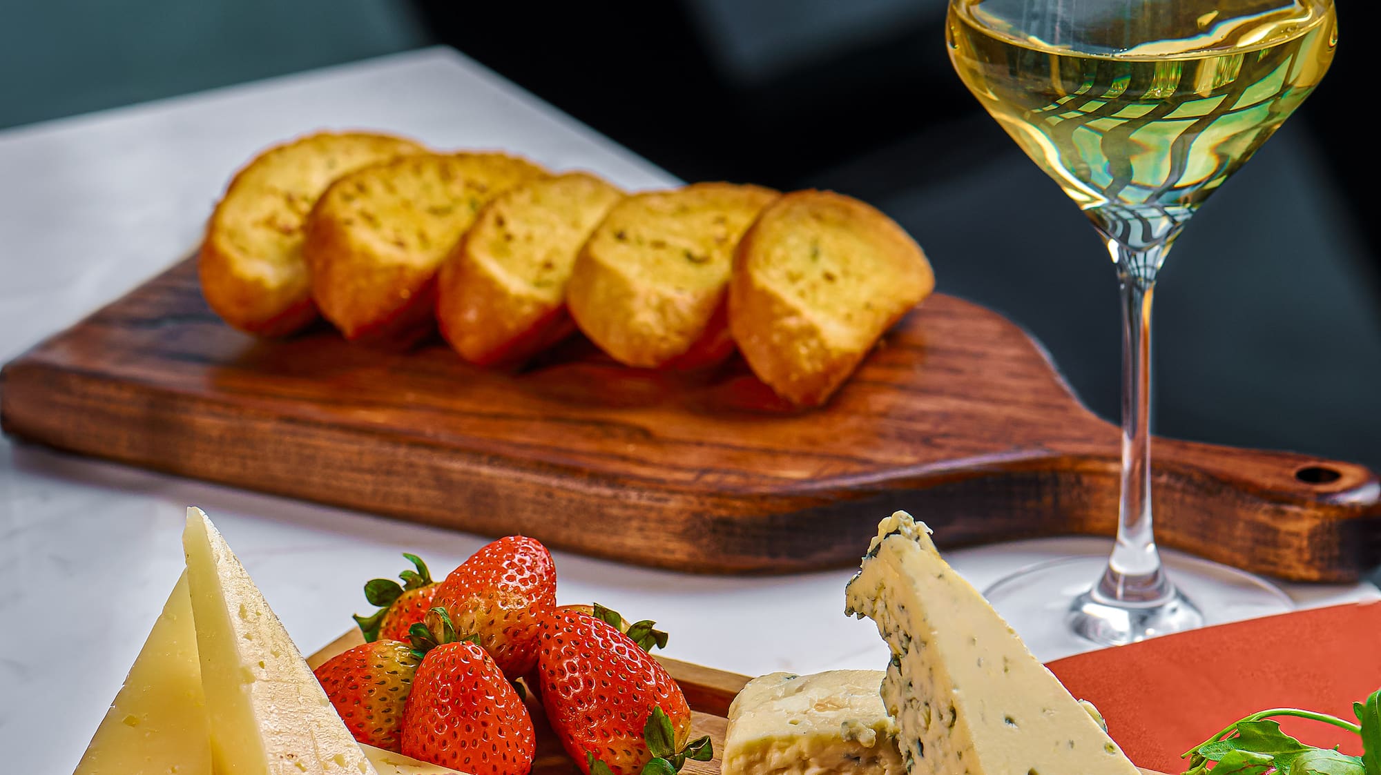 a cheese and fruit on a cutting board