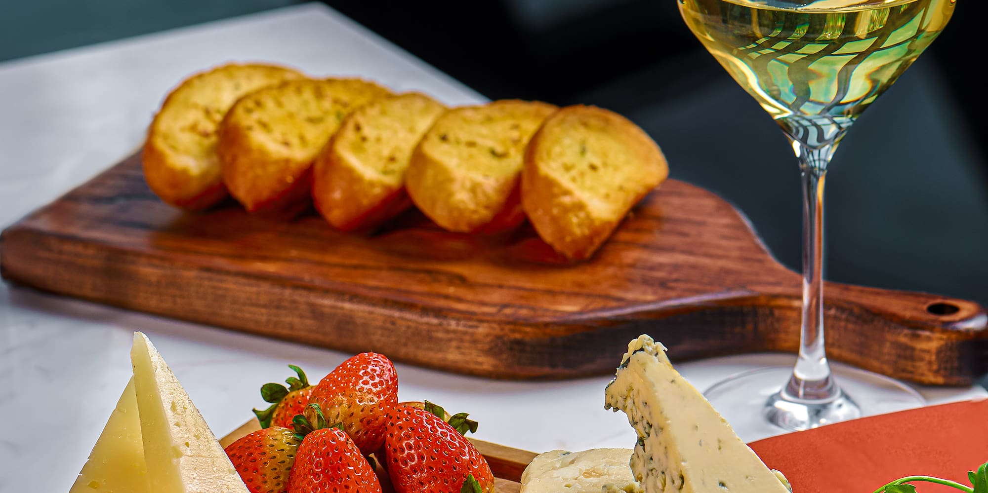 a cheese and fruit on a cutting board