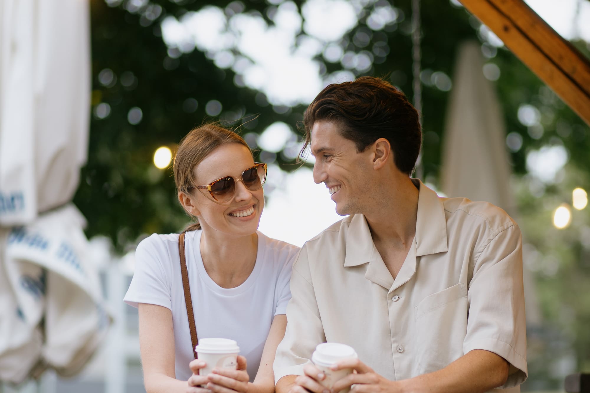 a man and woman holding coffee cups