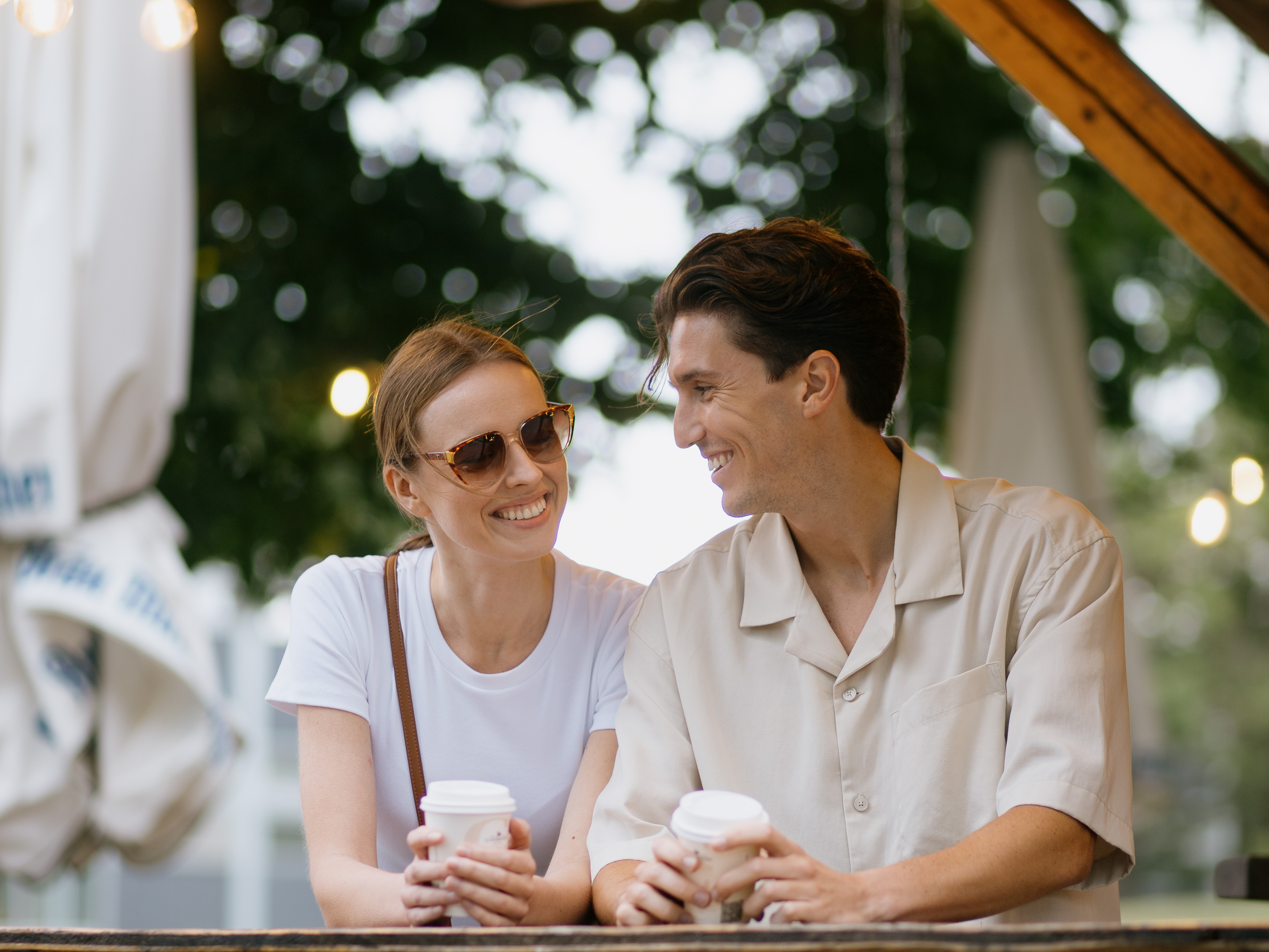 a man and woman holding coffee cups