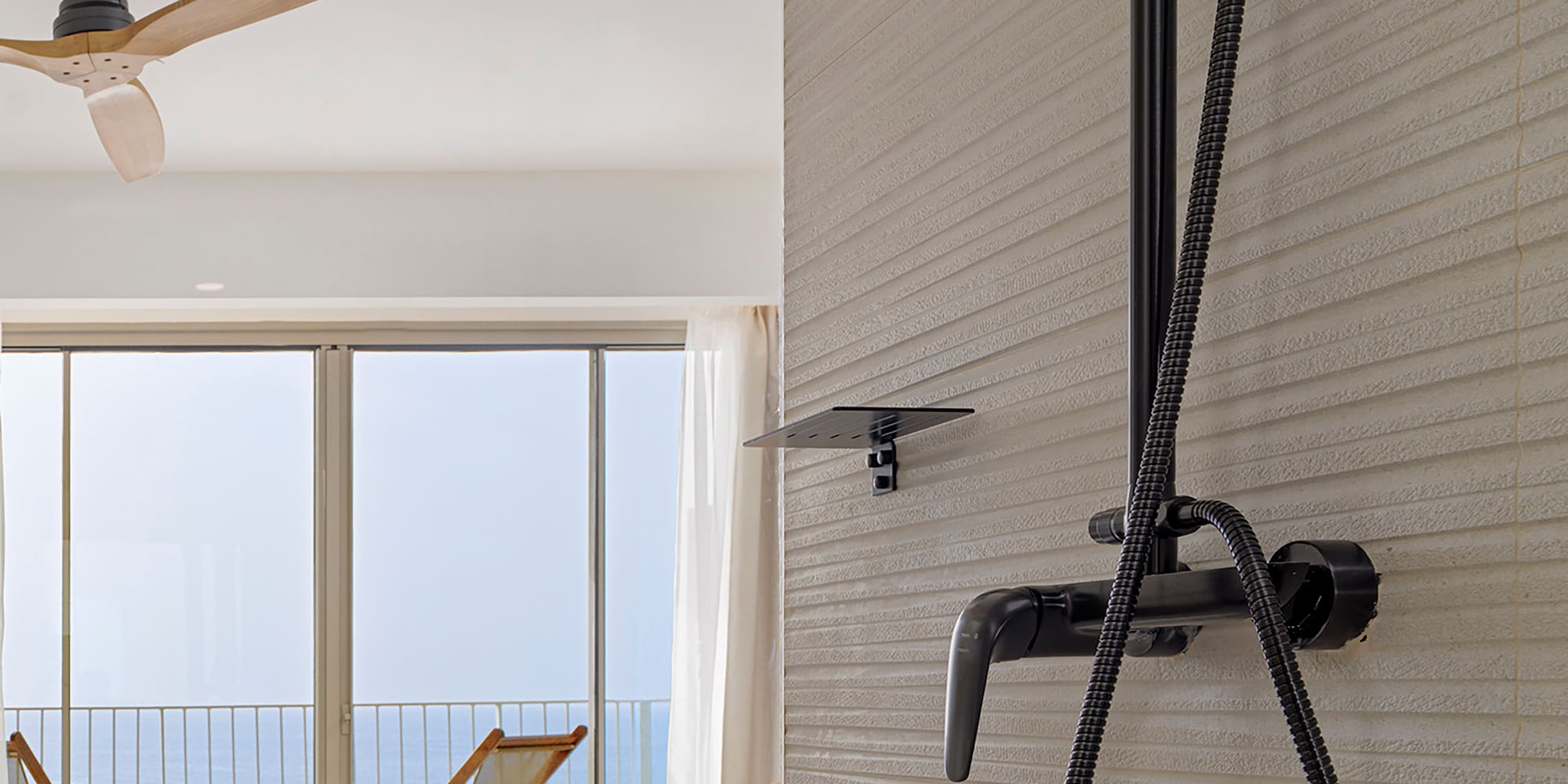 a shower head with a black hose attached to a wall