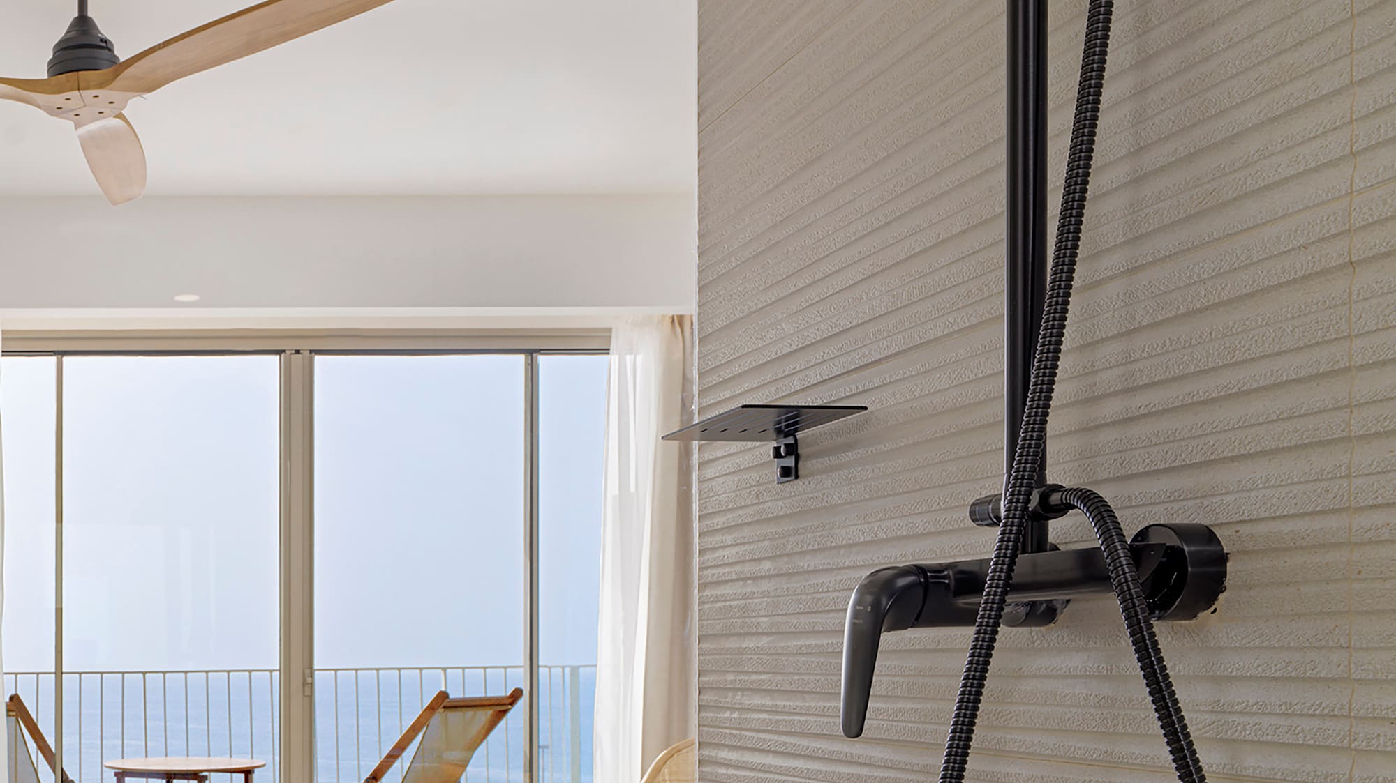 a shower head with a black hose attached to a wall