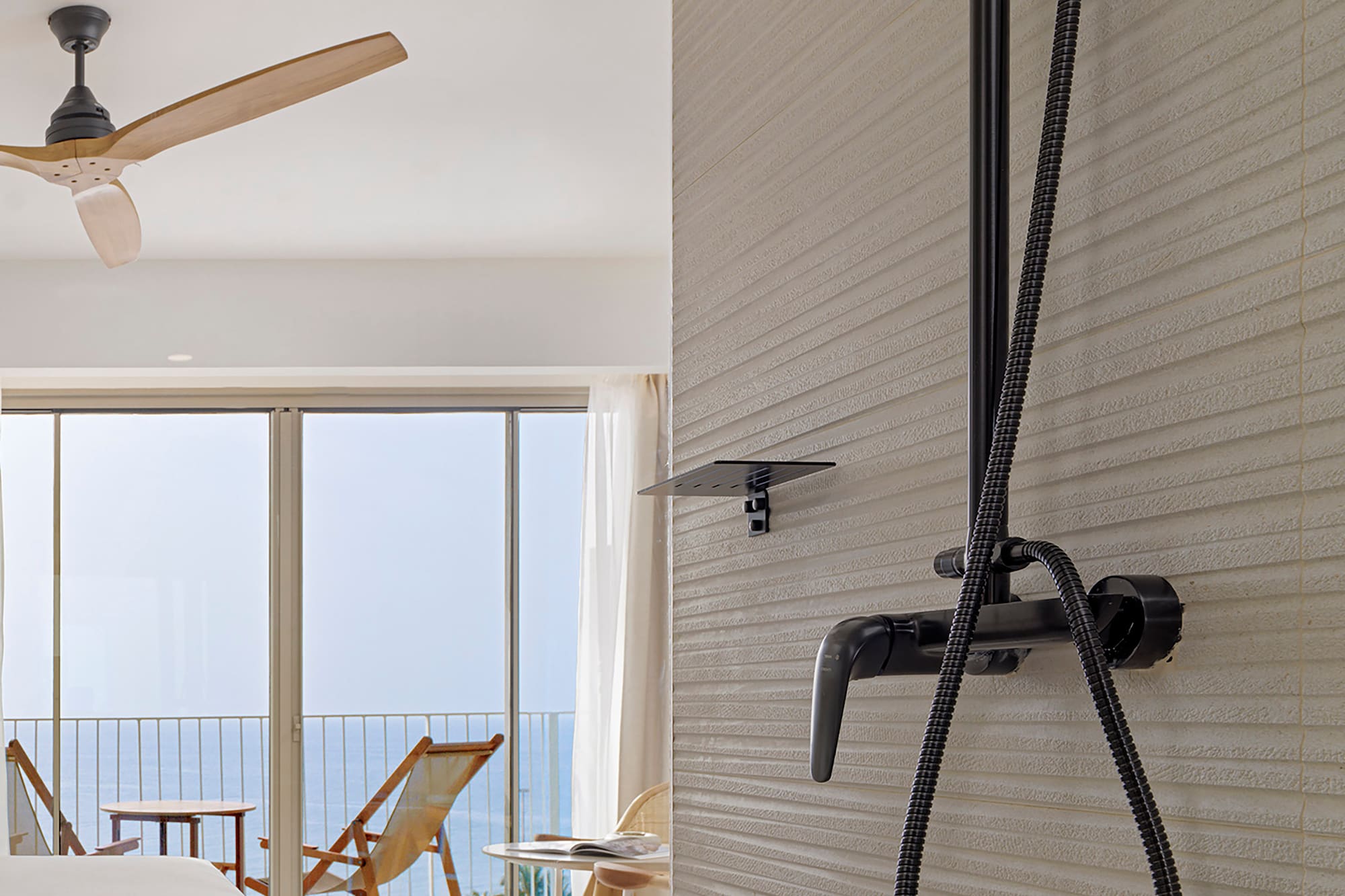 a shower head with a black hose attached to a wall