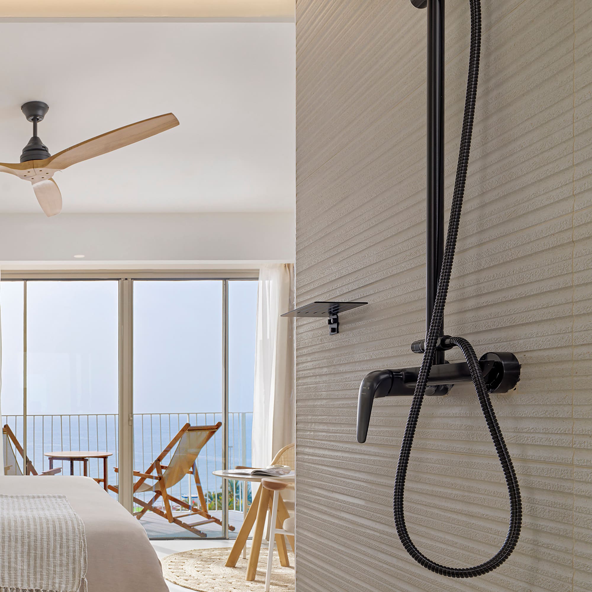 a shower head with a black hose attached to a wall