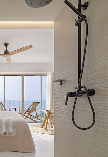 a shower head with a black hose attached to a wall