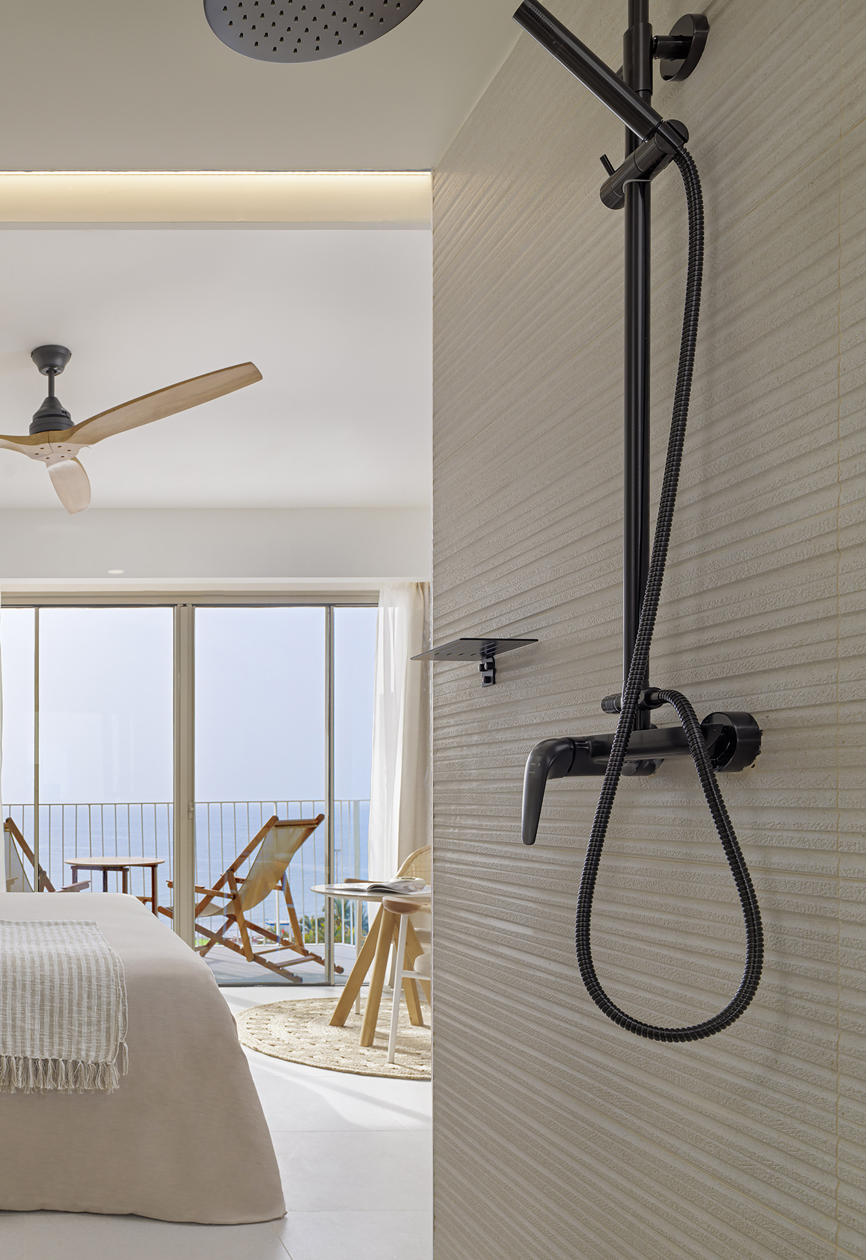 Contemporary hotel room featuring a black shower and ocean-view balcony.