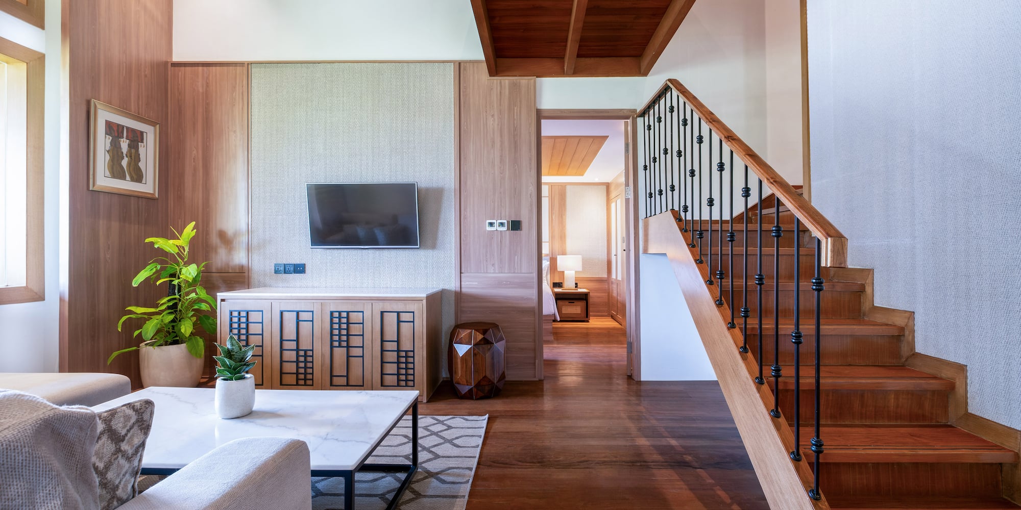 a living room with a staircase and a tv