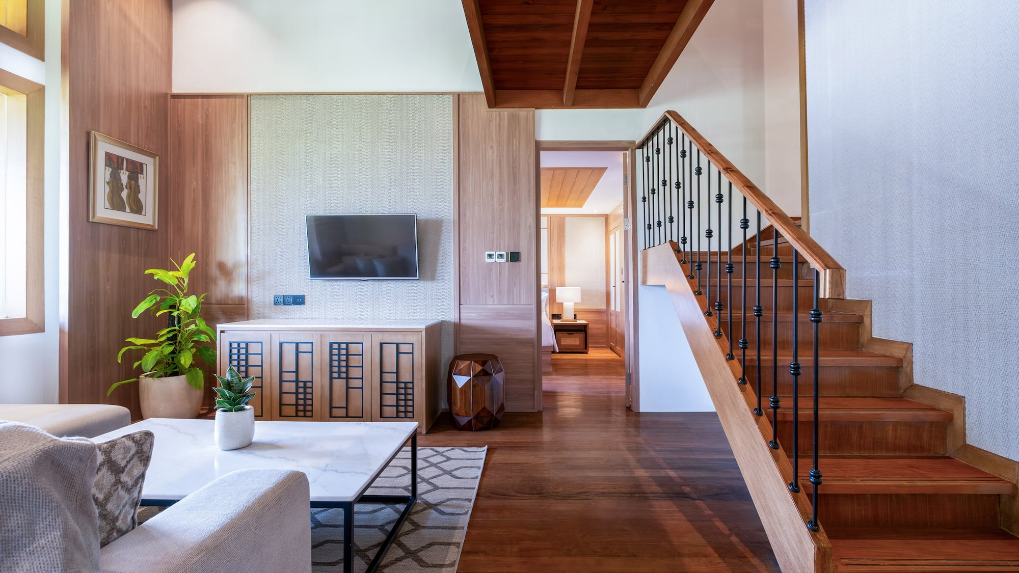 a living room with a staircase and a tv