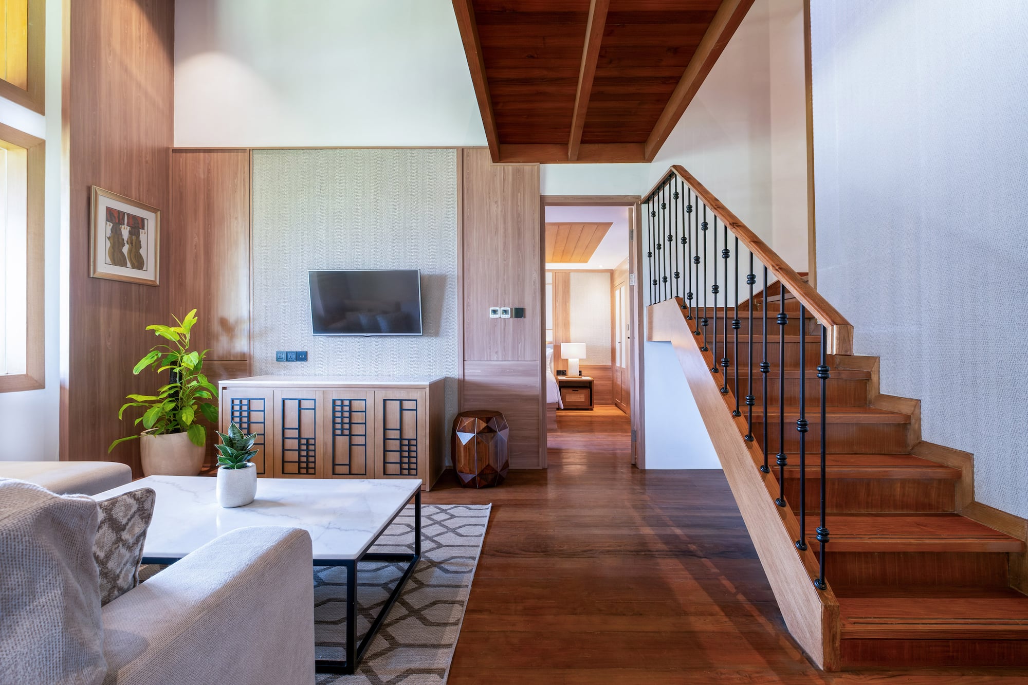a living room with a staircase and a tv