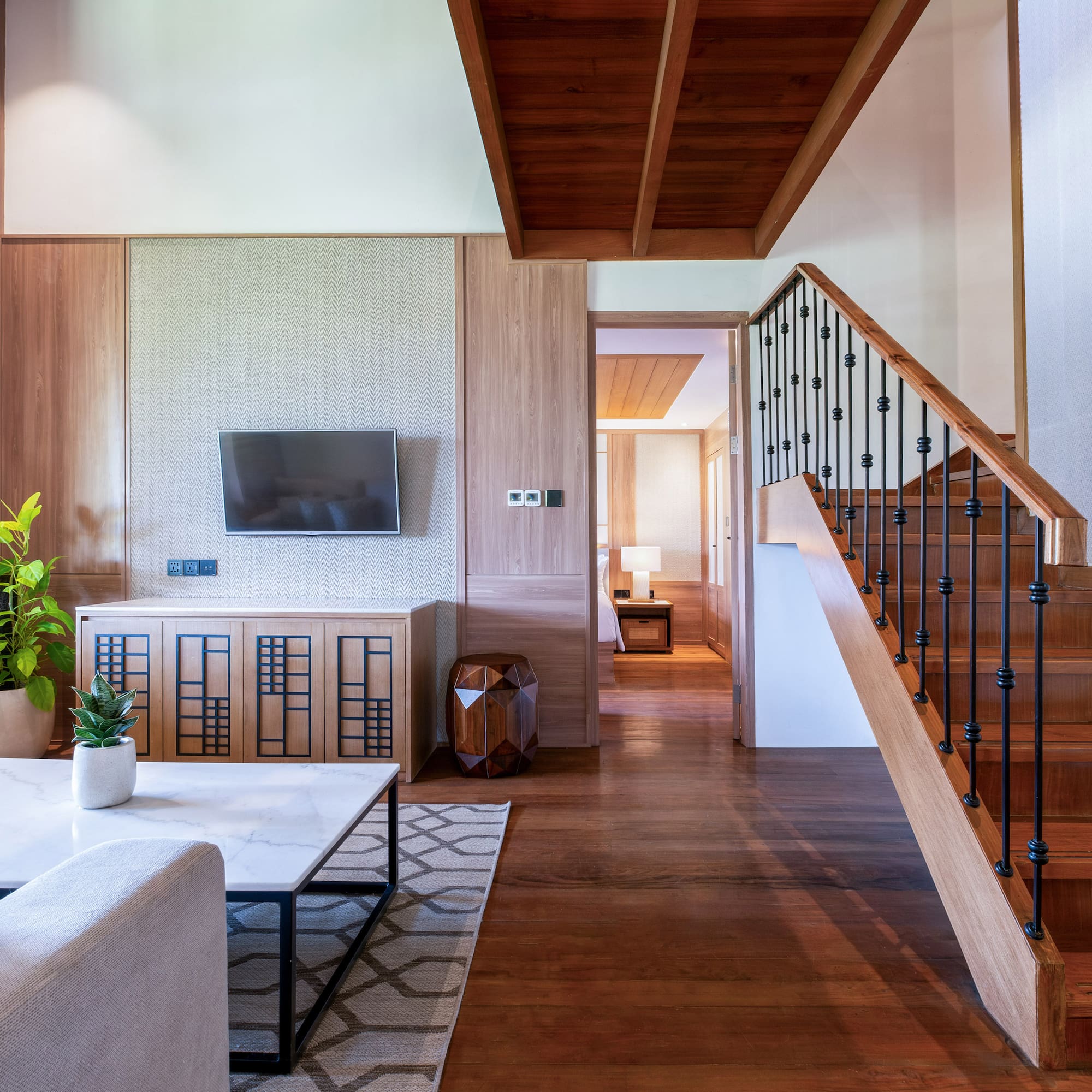 a living room with a staircase and a tv
