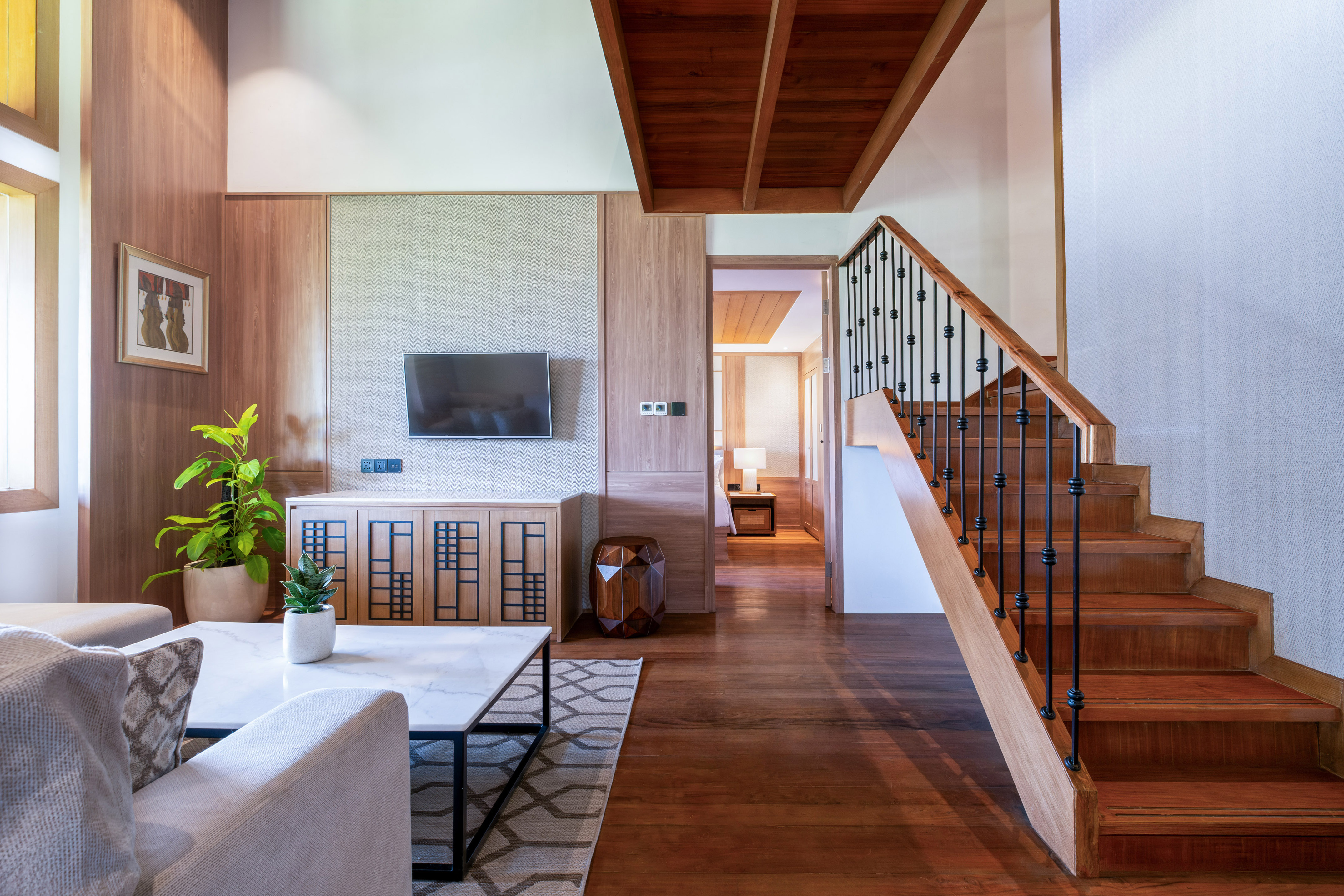 a living room with a staircase and a tv