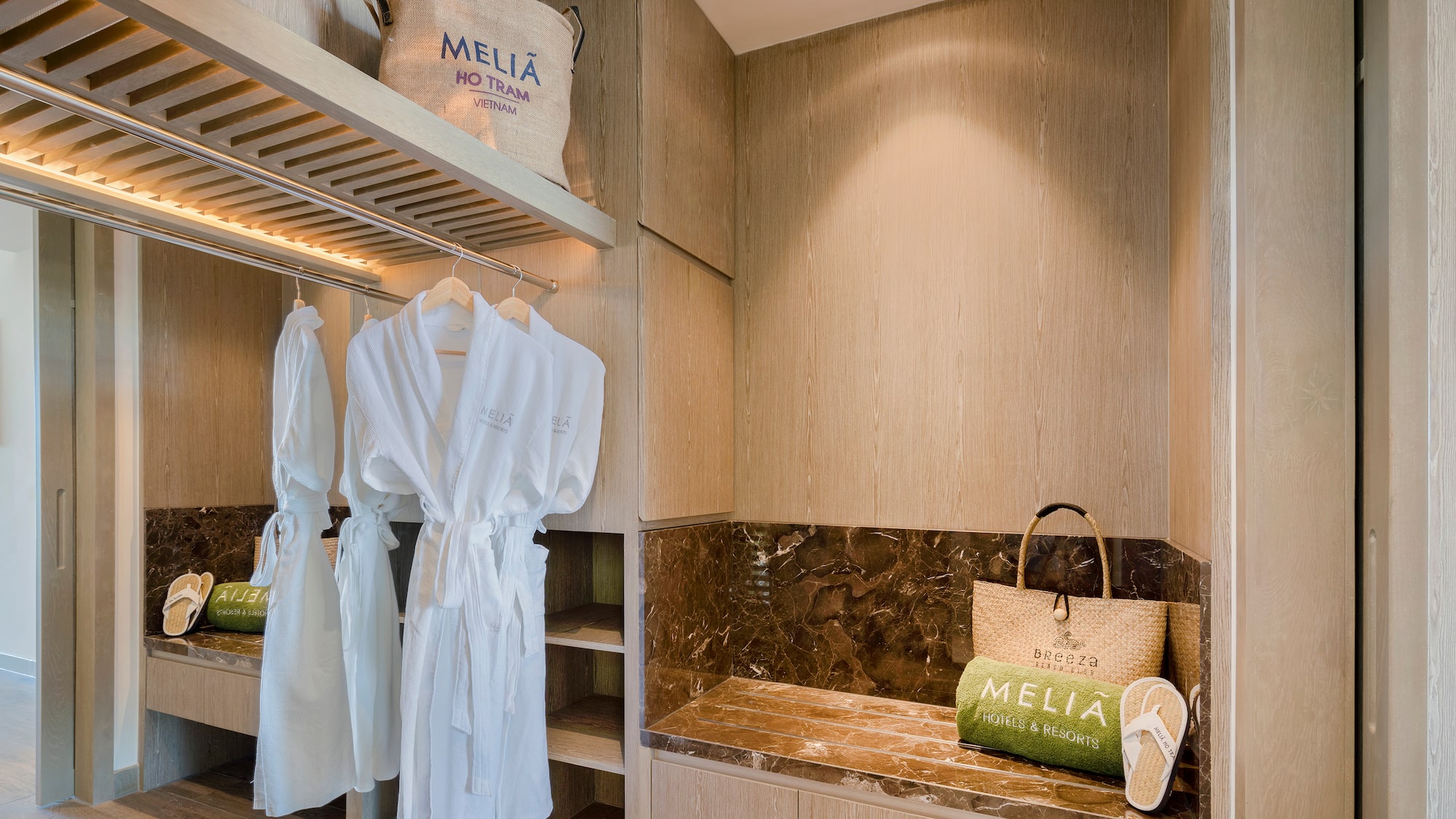 a room with white bathrobes and a bench