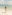 Child in blue striped swimsuit splashes in ocean waves at sunny beach.