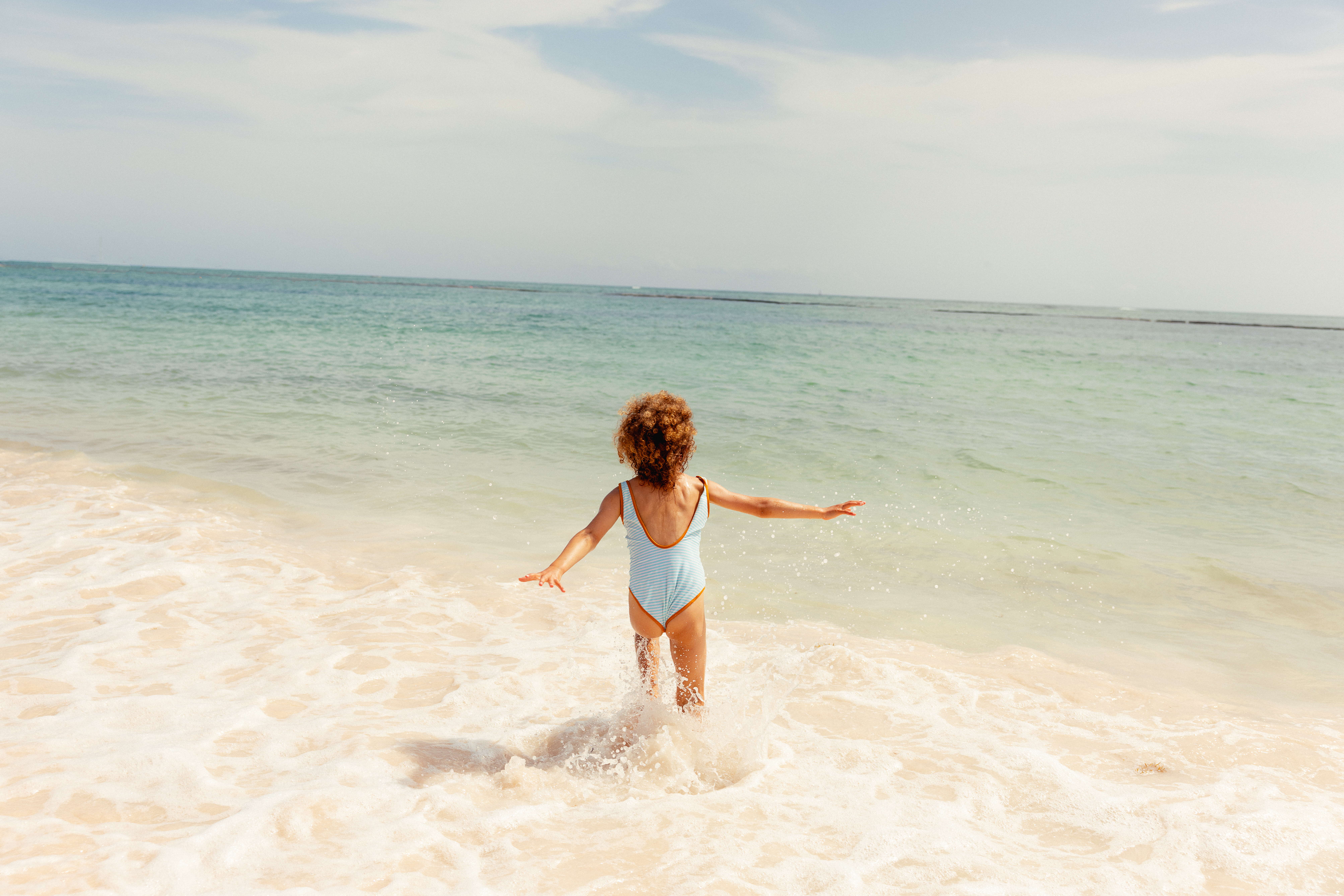 a child in a swimsuit on a beach